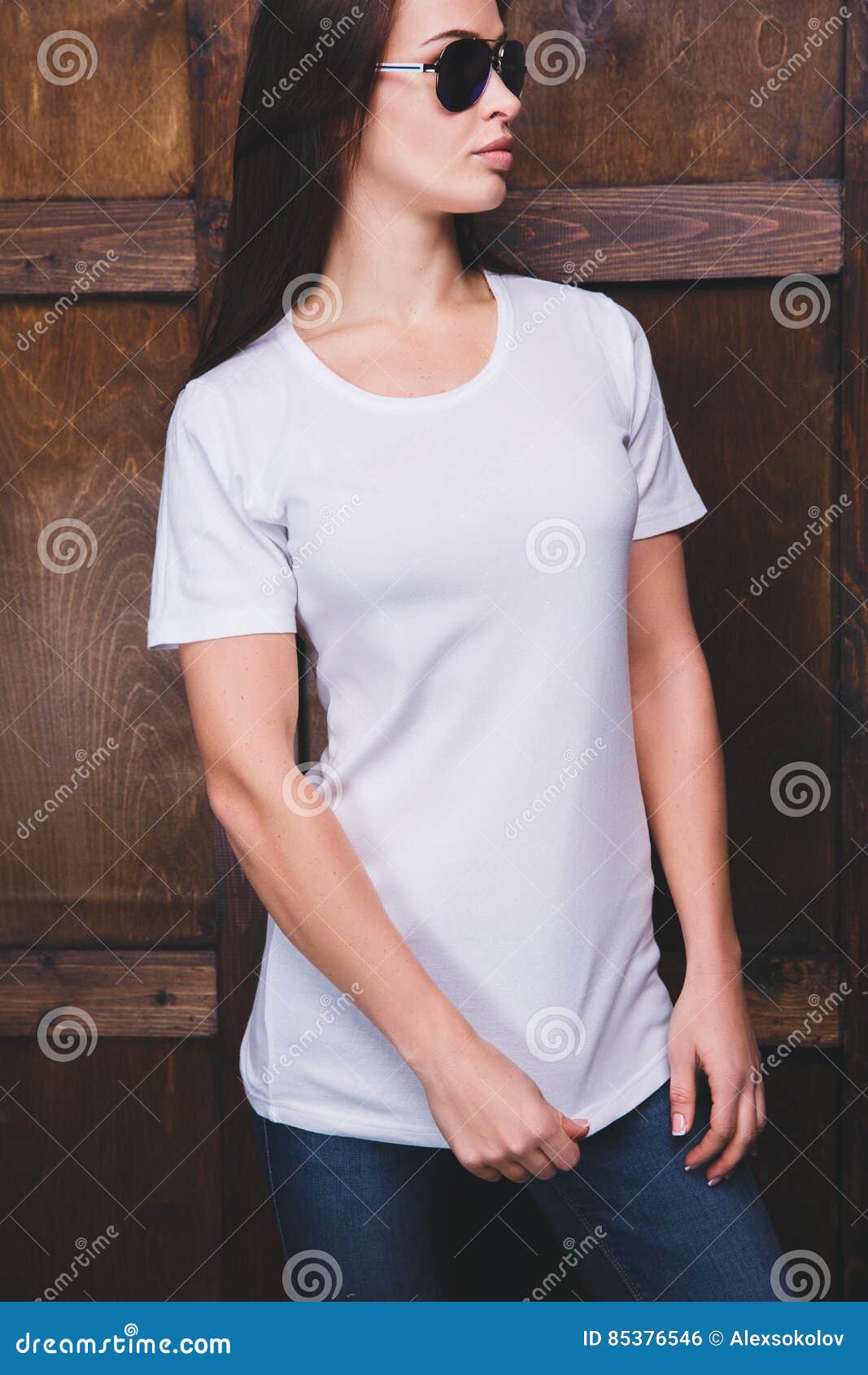 woman wearing white t-shirt in front of wooden wall