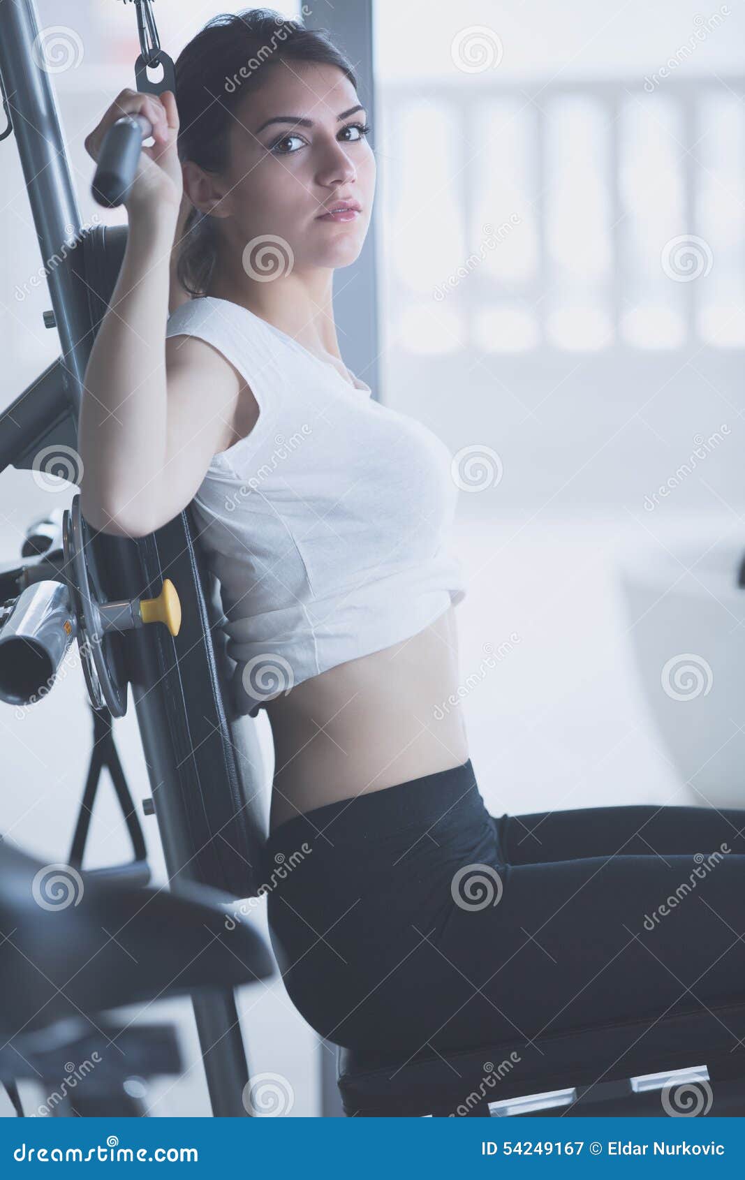 woman weight training at gym.exercising on pull down weight machine.woman doing pull-ups exercising lifting dumbbells.cardio and