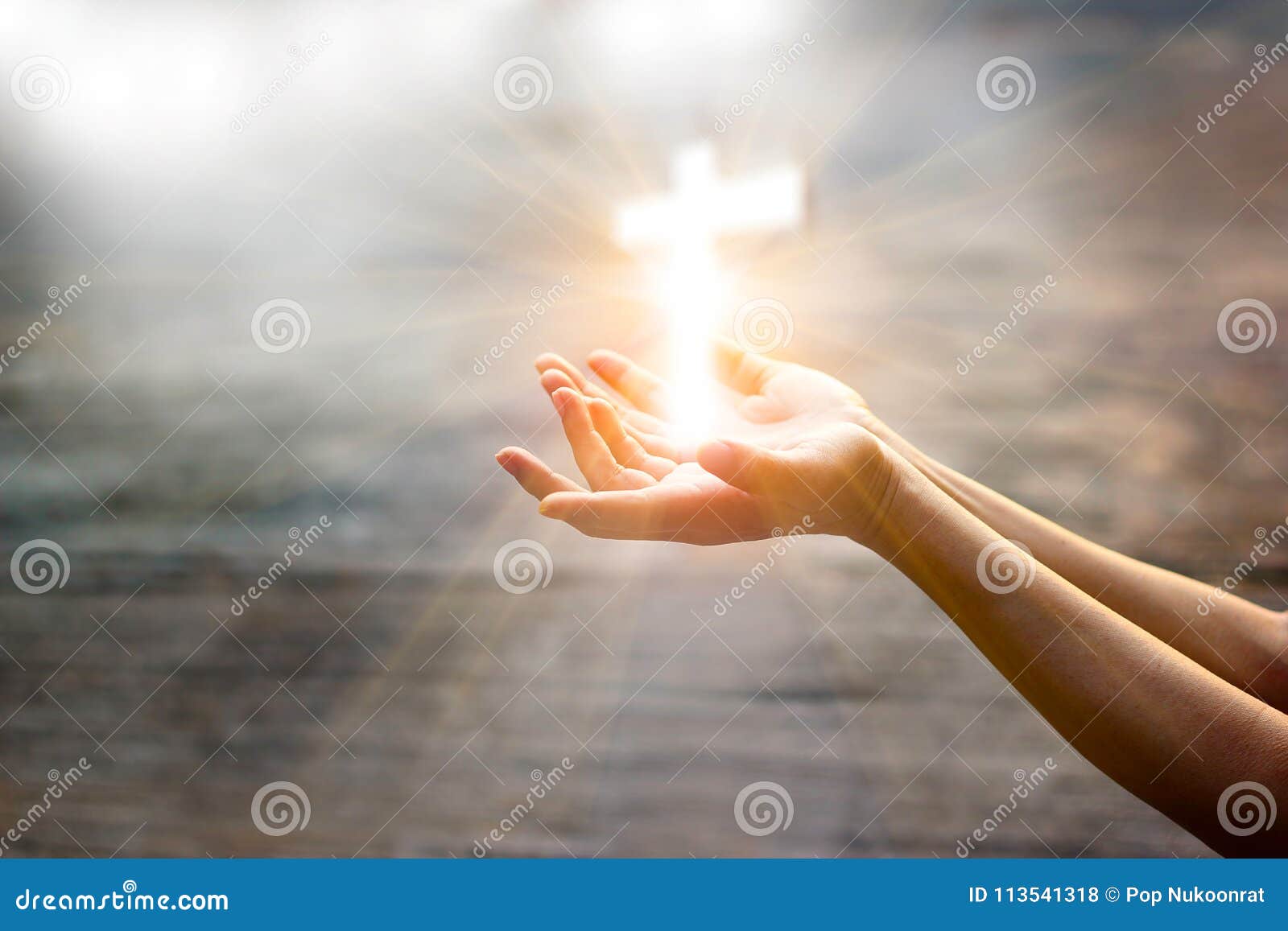 woman with white cross in hands praying on sunlight