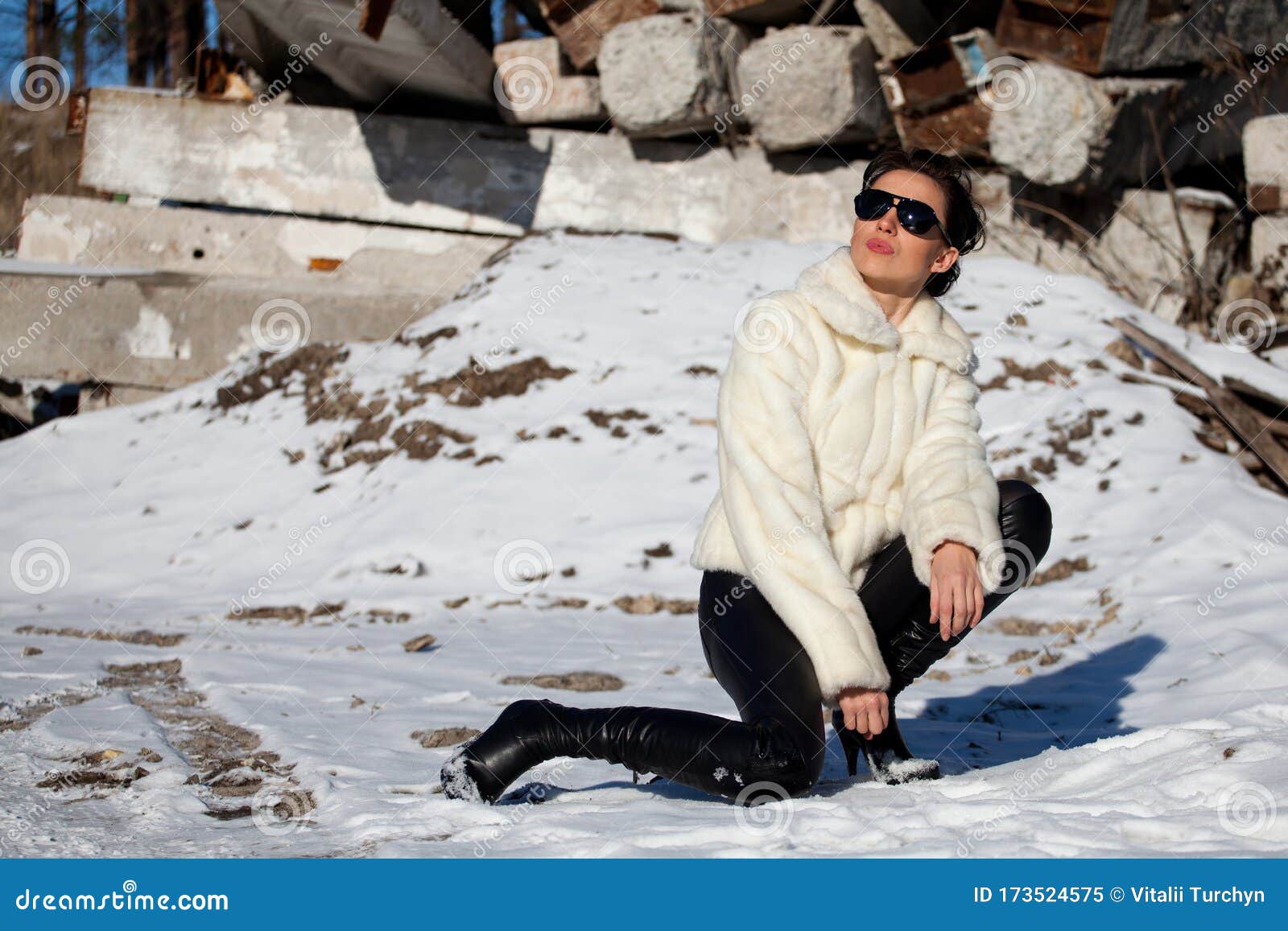 Woman in a White Short Fur Coat and Black Trousers Posing Outdoors ...