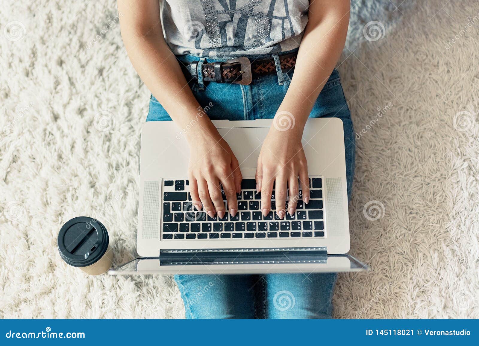 woman working on a laptop. female using a laptop sitting on floor, searching web, browsing information, having workplace at home.