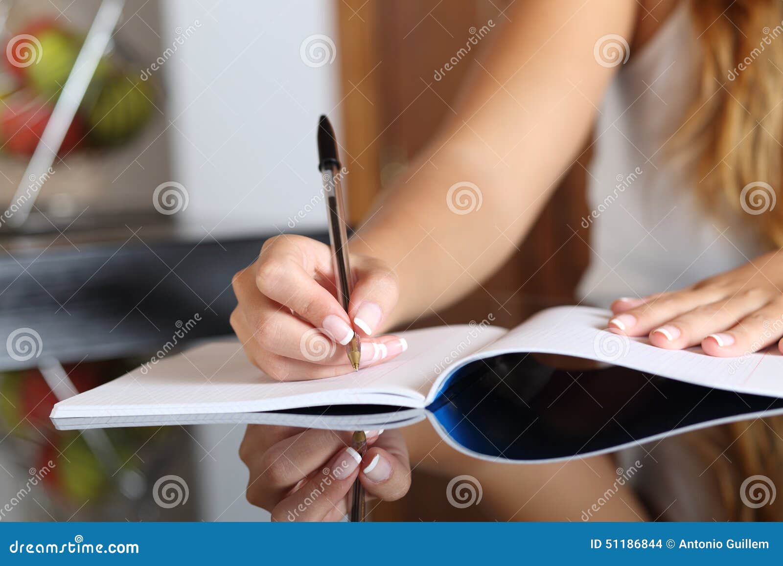 woman writer hand writing in a notebook at home