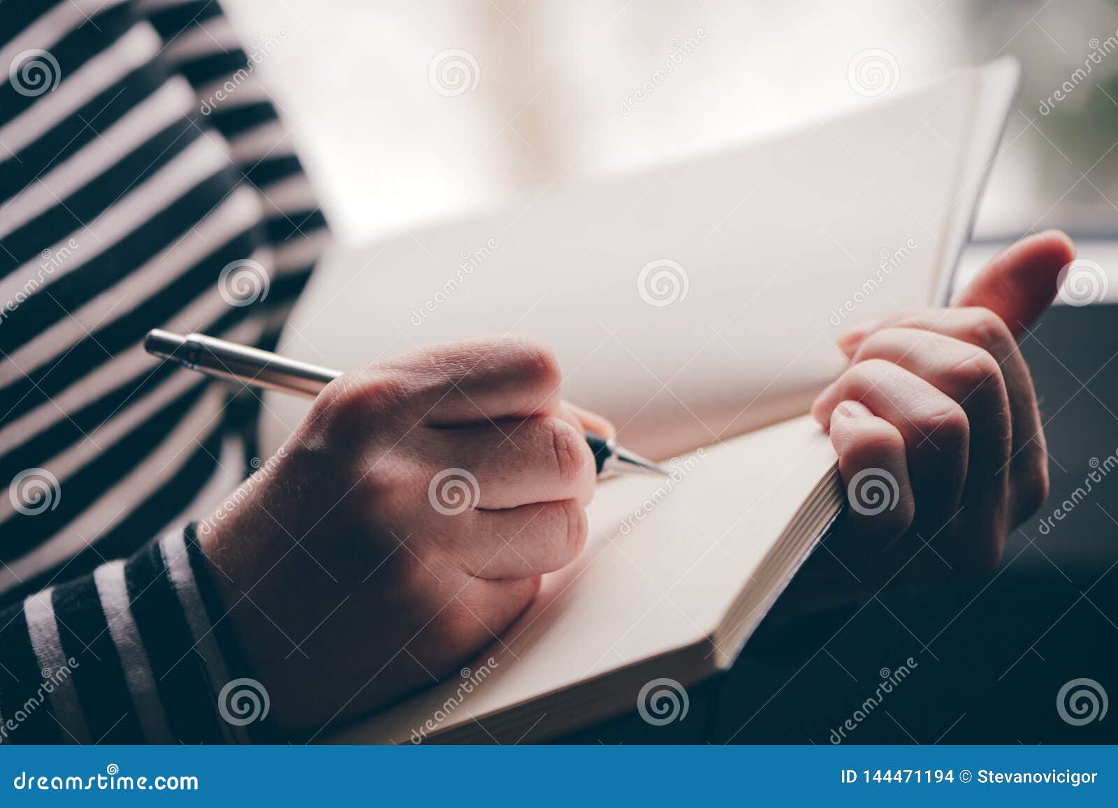 woman writing diary by the window