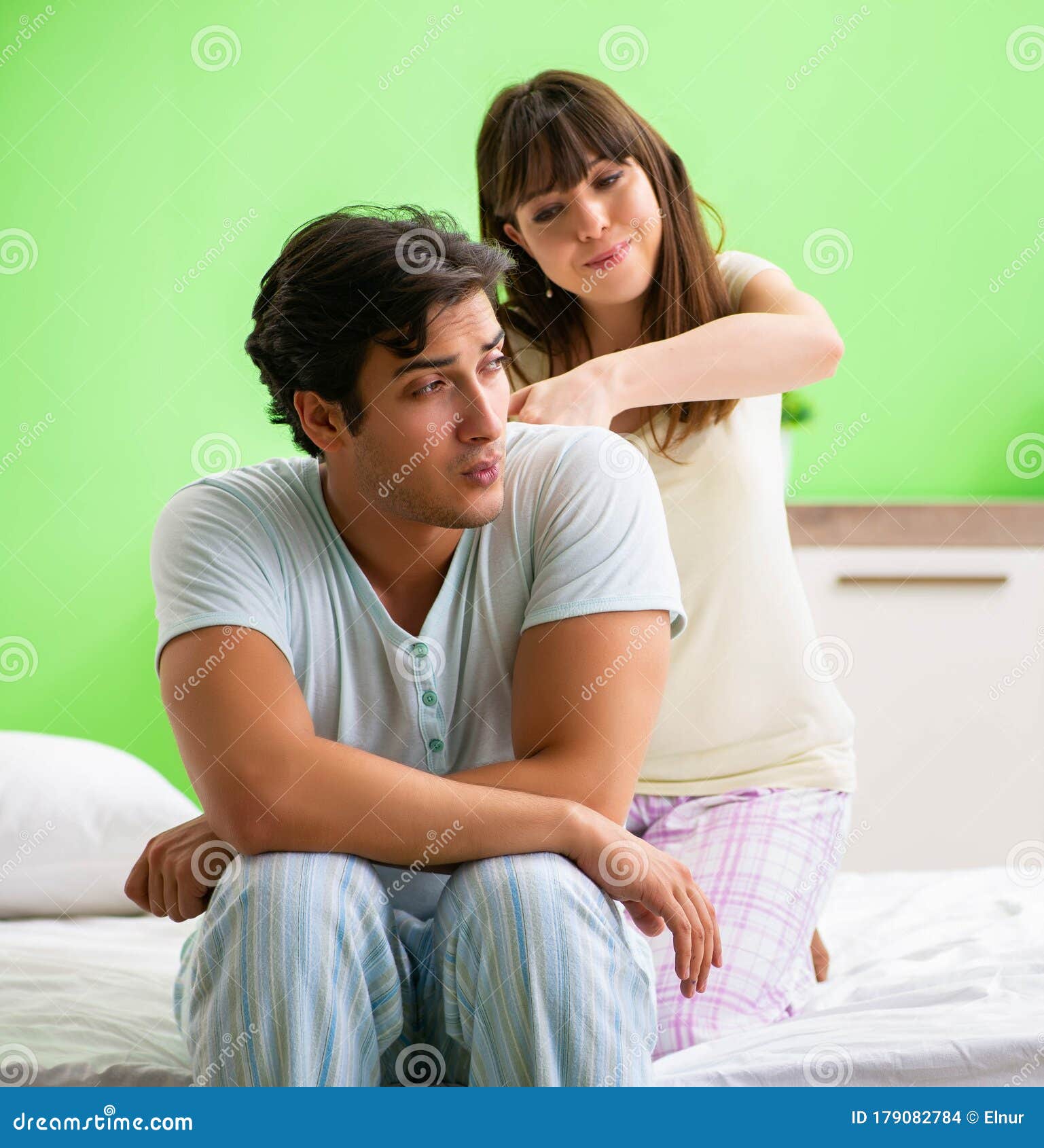 Woman Doing Massage To Her Husband in Bedroom Stock Photo