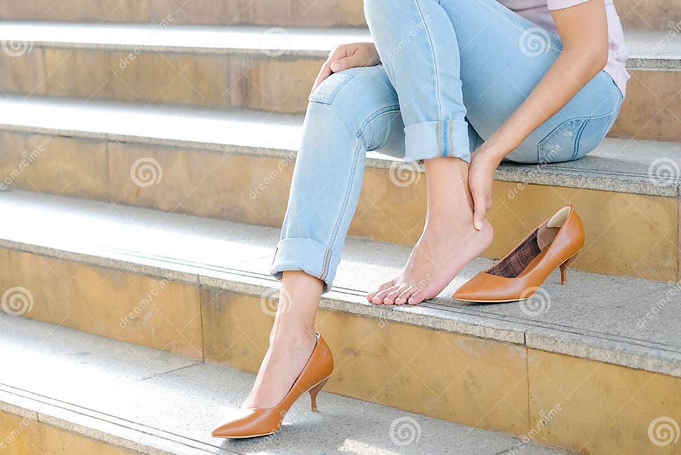 Women with Leg Cramps and Ankles from High Heels. she Sat on the Stairs ...