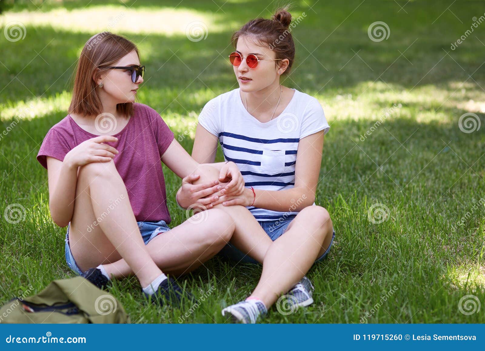 Women Lesbians Have Fun Together While Sit Crossed Legs On Green Grass Look With Love At Each