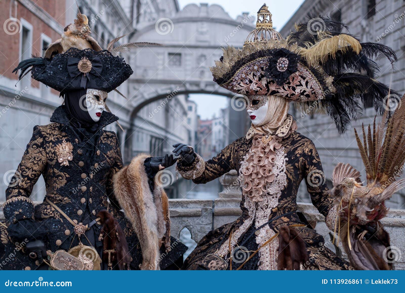 https://thumbs.dreamstime.com/z/women-masks-dressed-black-gold-costumes-carrying-birdcage-standing-bridge-sighs-background-venice-113926861.jpg