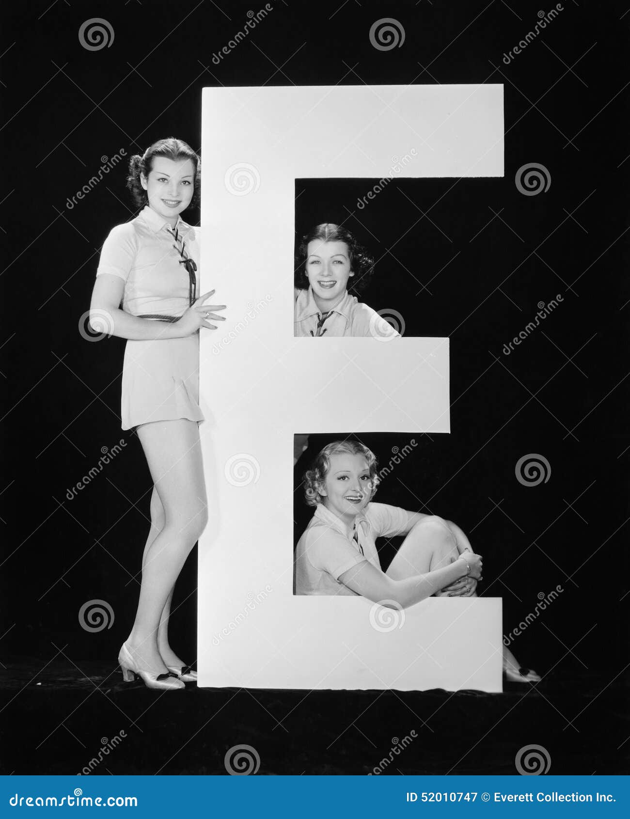 women posing with huge letter e