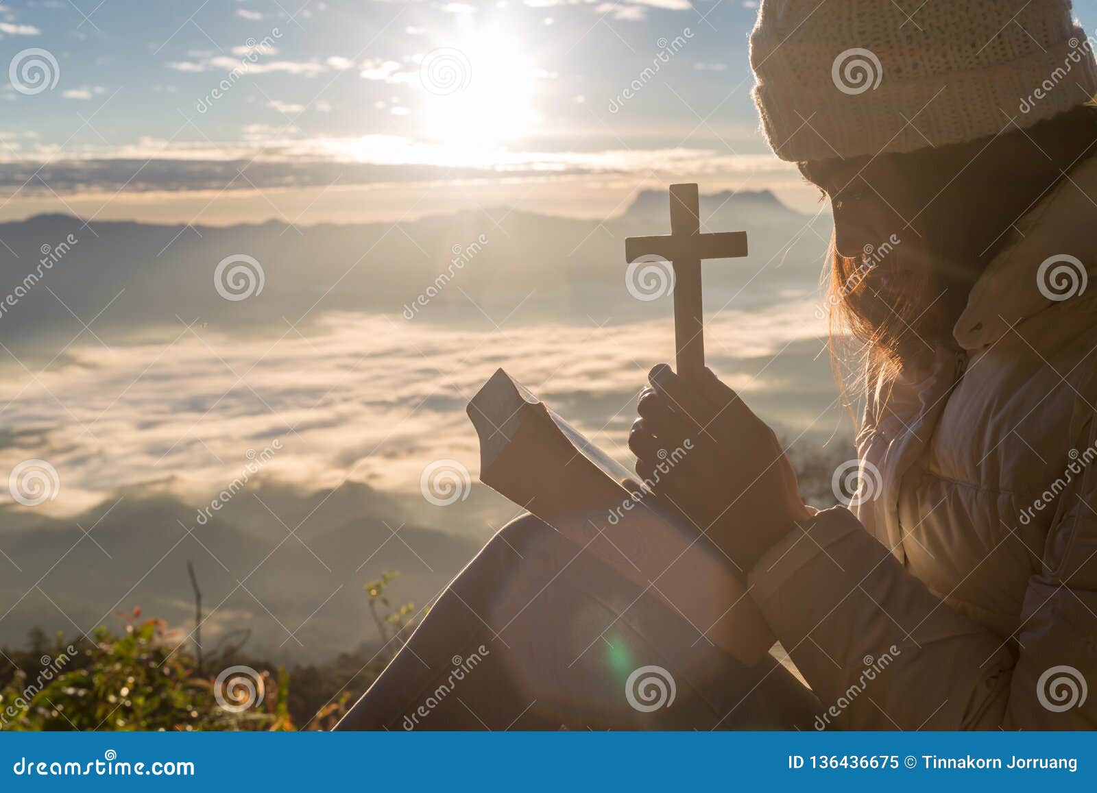 women pray to god with the cross on the mountain background with morning sunrise. woman pray for god blessing to wishing have a