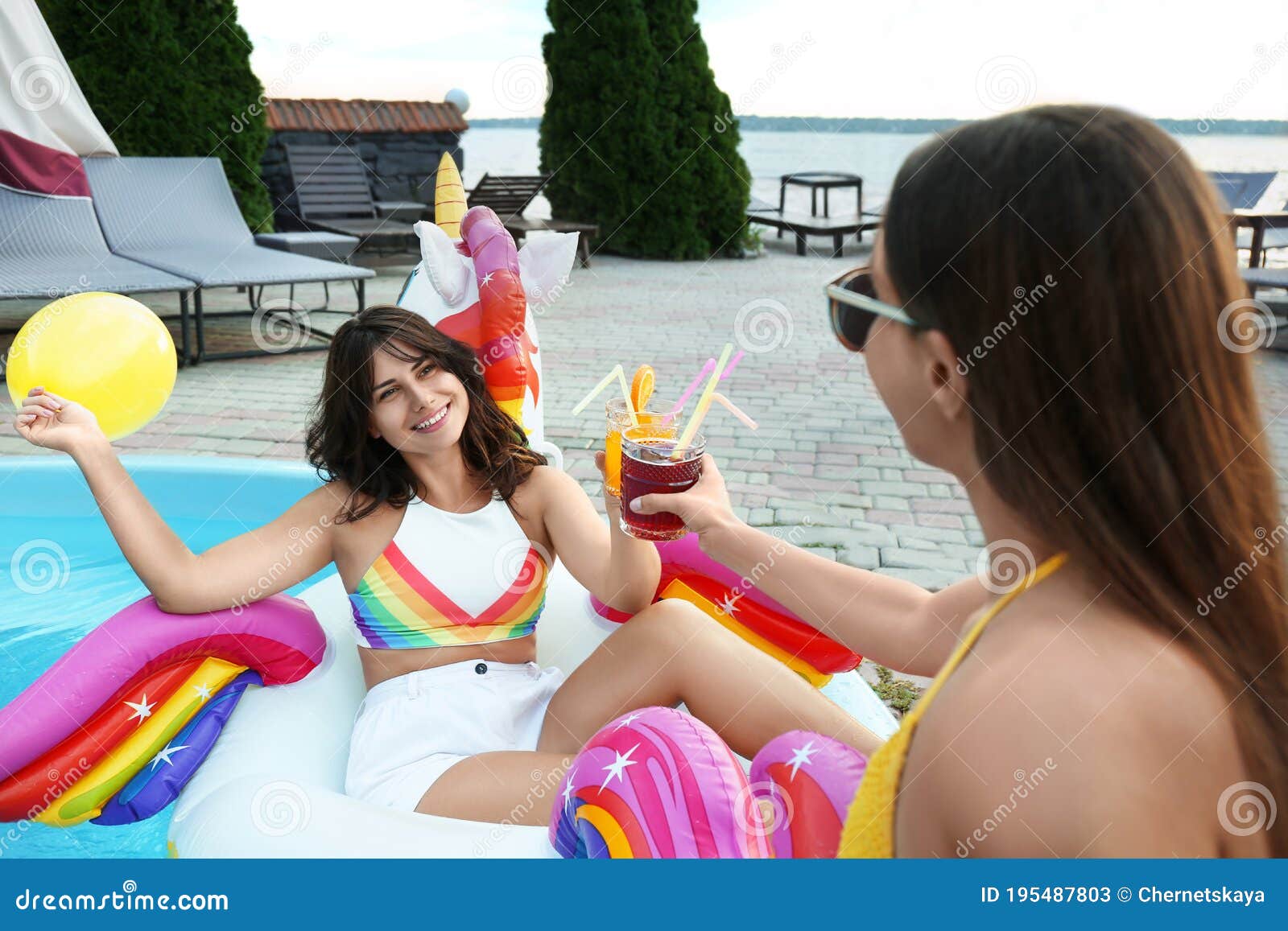 Women with Refreshing Drinks Enjoying Fun Pool Party Stock Image