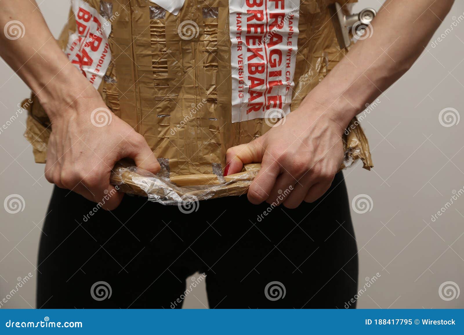 a women removing fragile packaging from her body. emotional baggage concept