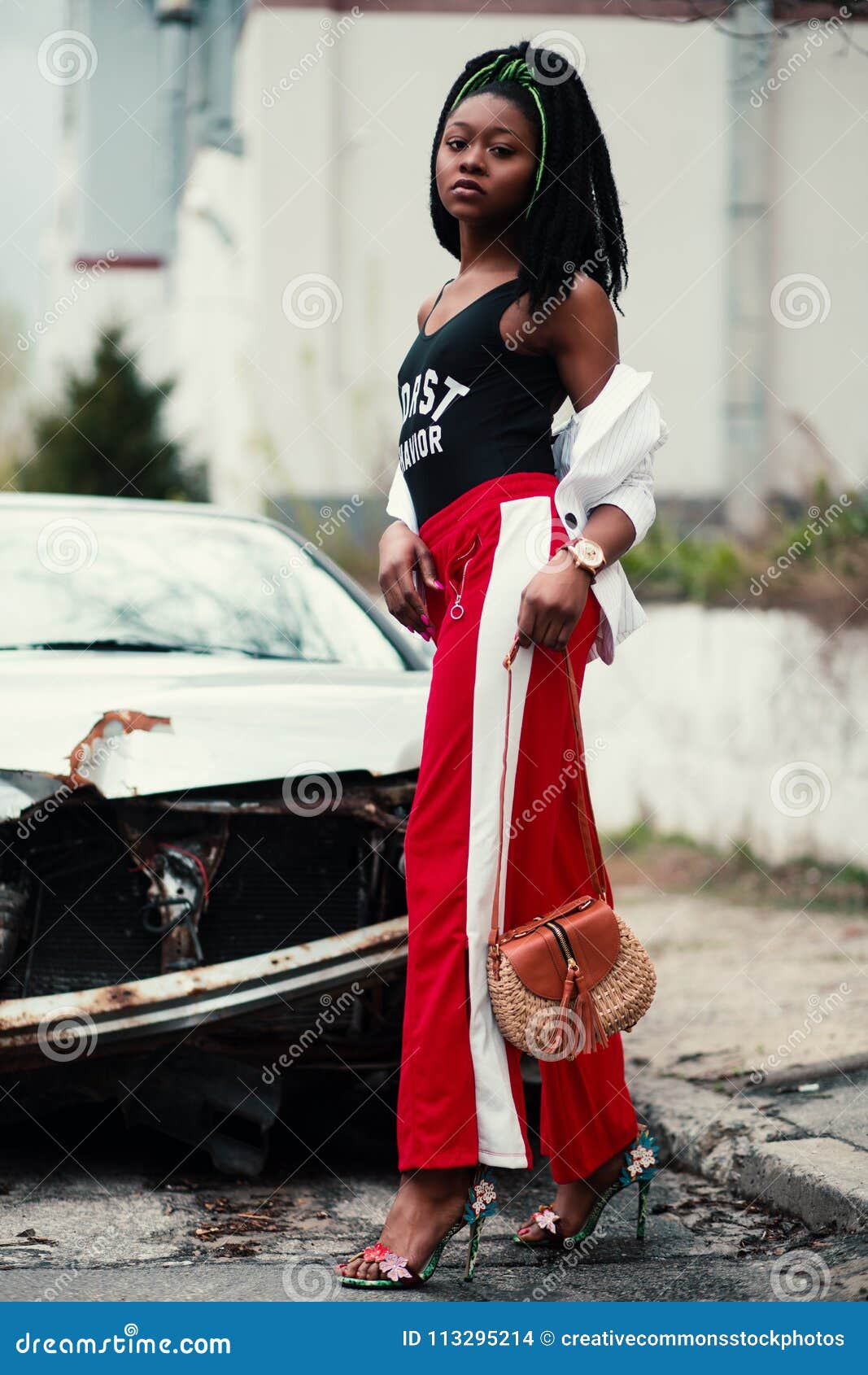 Women's Black Tank Top And Red Track Pants Walking On Street