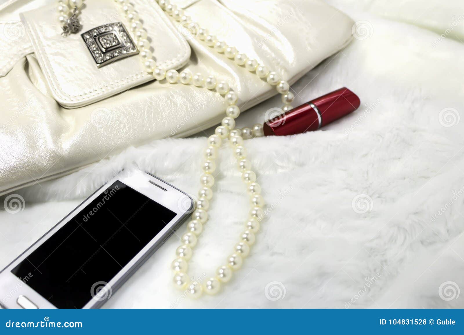 Women`s Clutch, Lipstick, Necklace, Phone on White Fur. Stock Photo ...