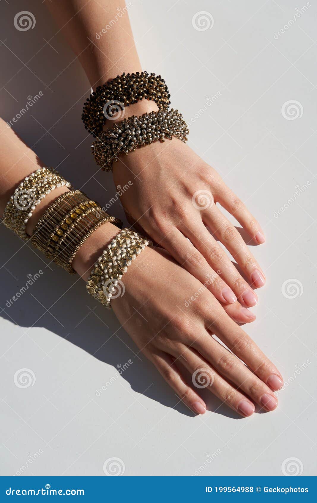 Stylish bracelets and clock on female hand top view Stock Photo by  ©belchonock 67205137