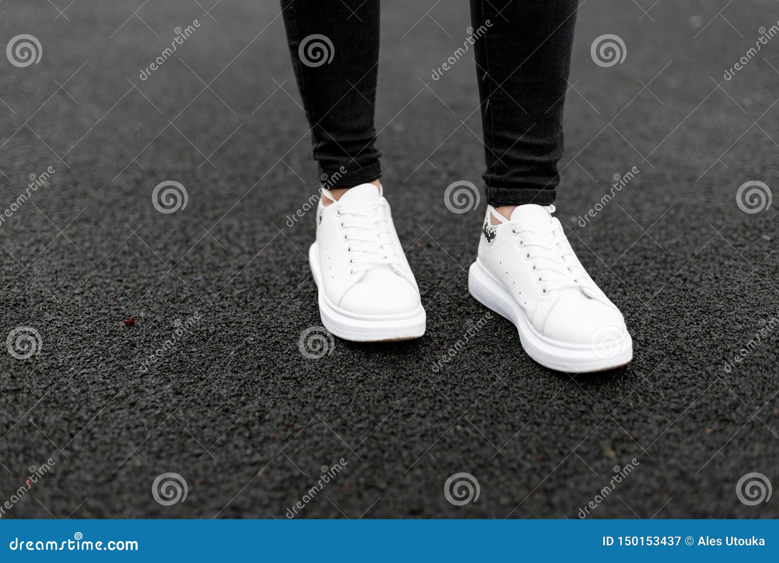 Women`s Legs in Black Jeans in Fashionable White Leather Sneakers Stand ...