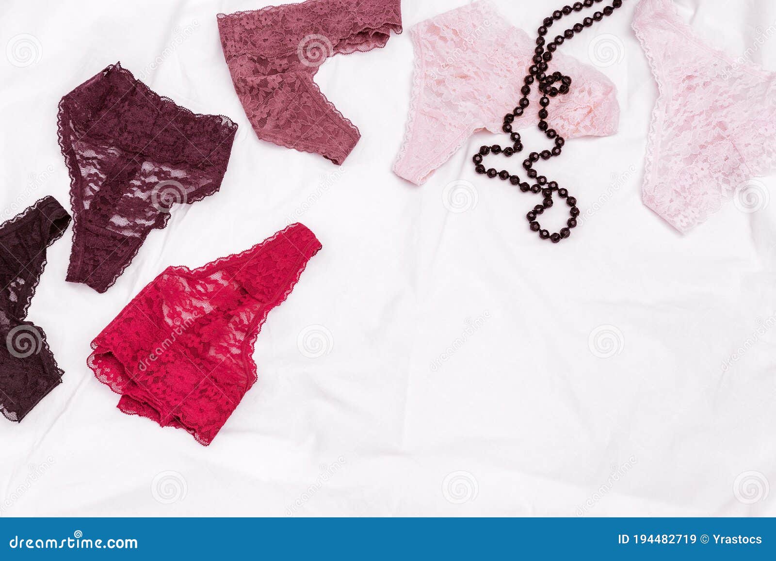 Women`s Lingerie on White Bed Sheet. Many Different Lace Bikini Panties and  Black Beads Stock Image - Image of desire, flatlay: 194482719