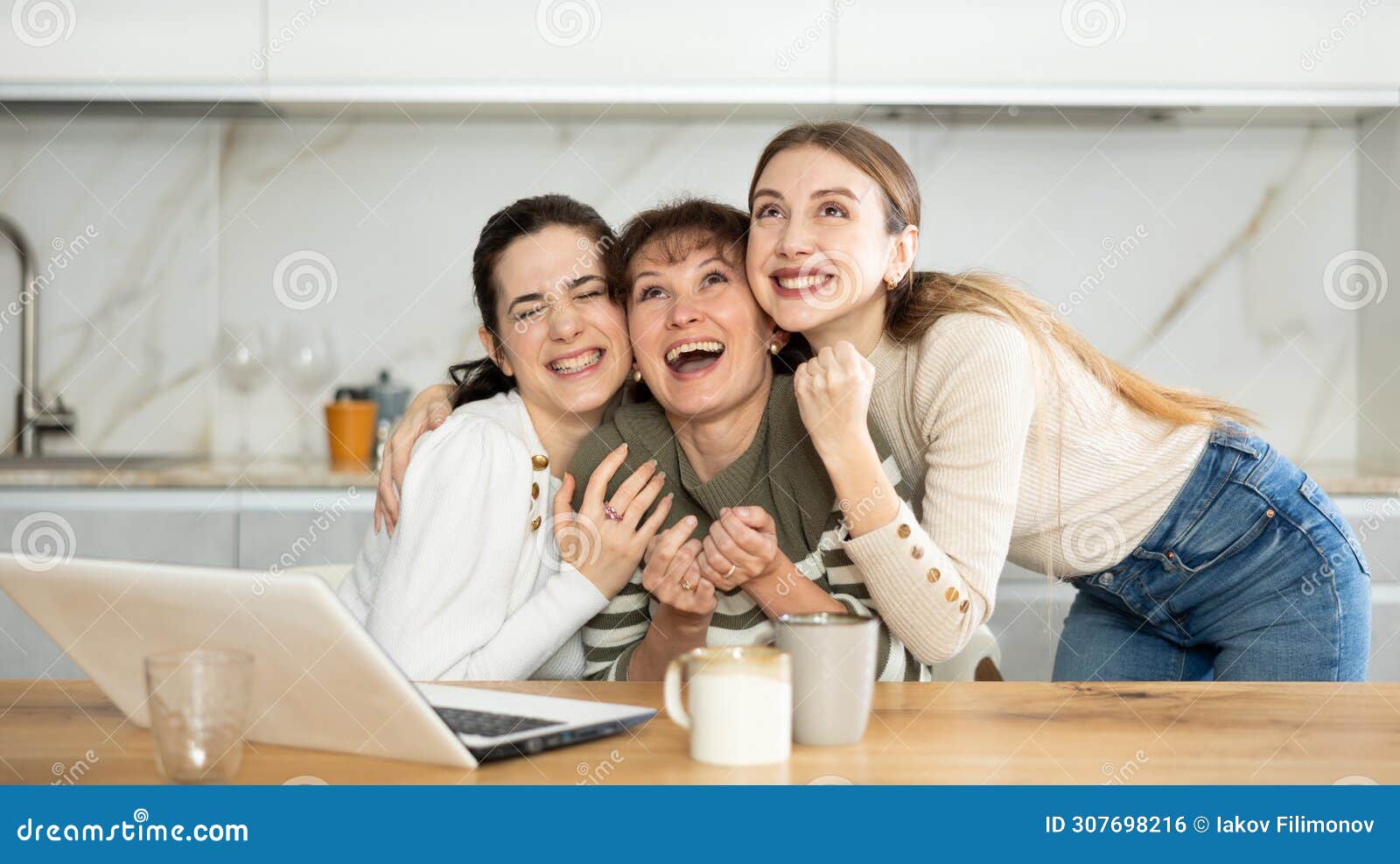 women are sitting at computer and are immensely happy