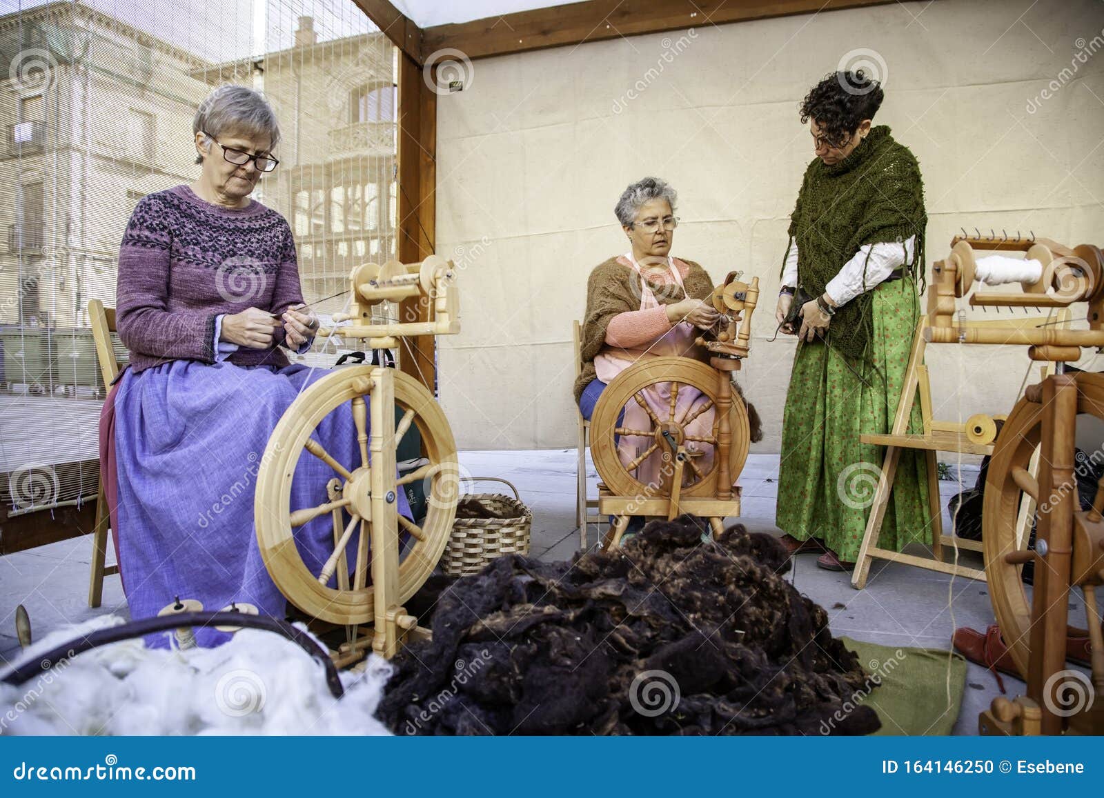 Women Spinning Thread with a Wooden Spinning Wheel Editorial Image