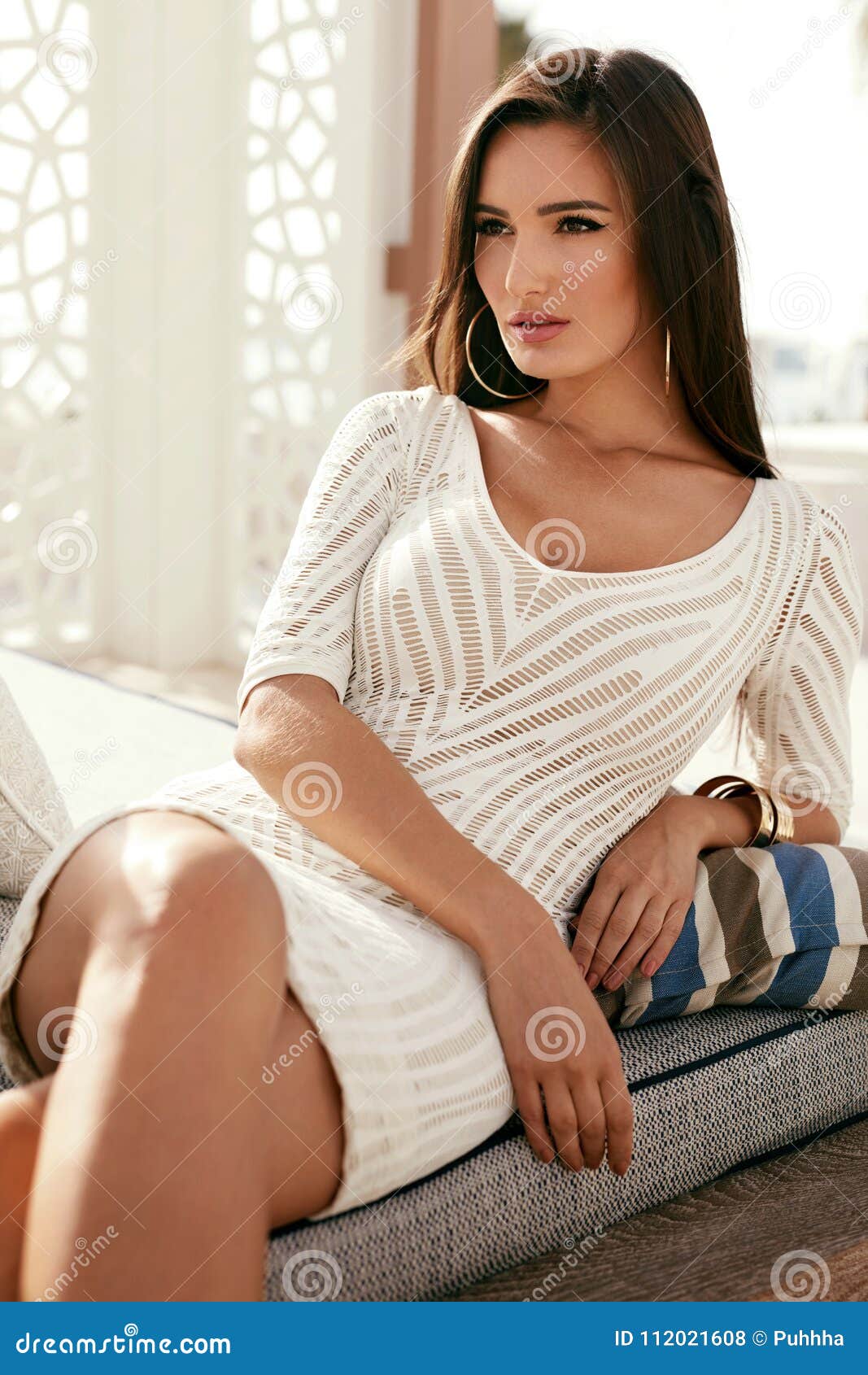 Women Style. Beautiful Woman In Stylish Fashion Clothes. Young Sexy Female  Model In Fashionable White Dress With Natural Makeup Sitting On Sofa And  Enjoying Vacation At Resort. High Resolution Stock Photo, Picture