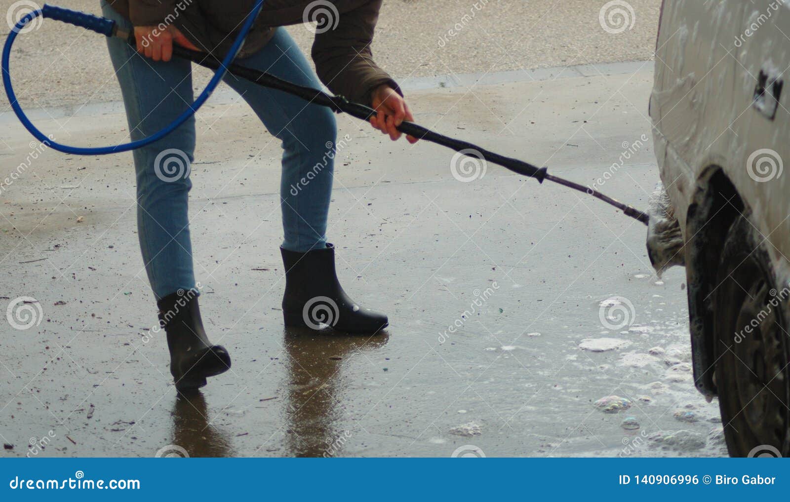 A Women Wearing Wellingtons and Washing a Car. Stock Photo Image of
