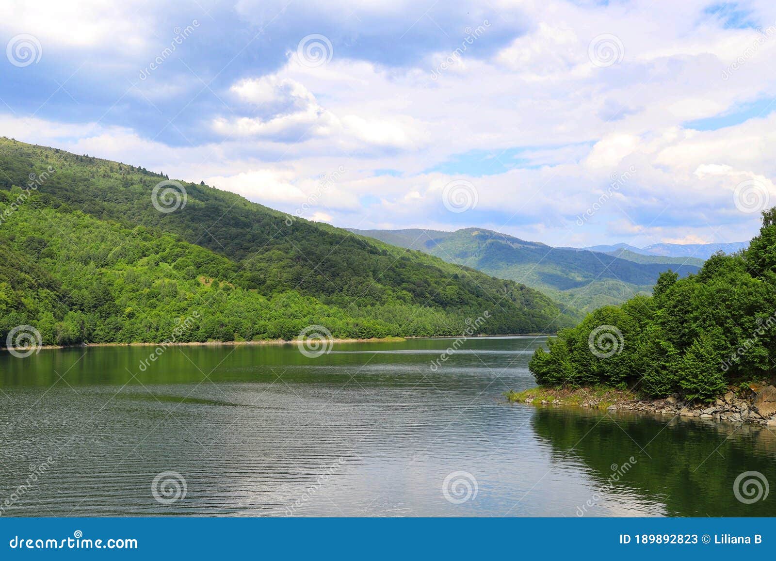 wonderful lake with clouds and a lot of vegetation all around. beautiful valley.