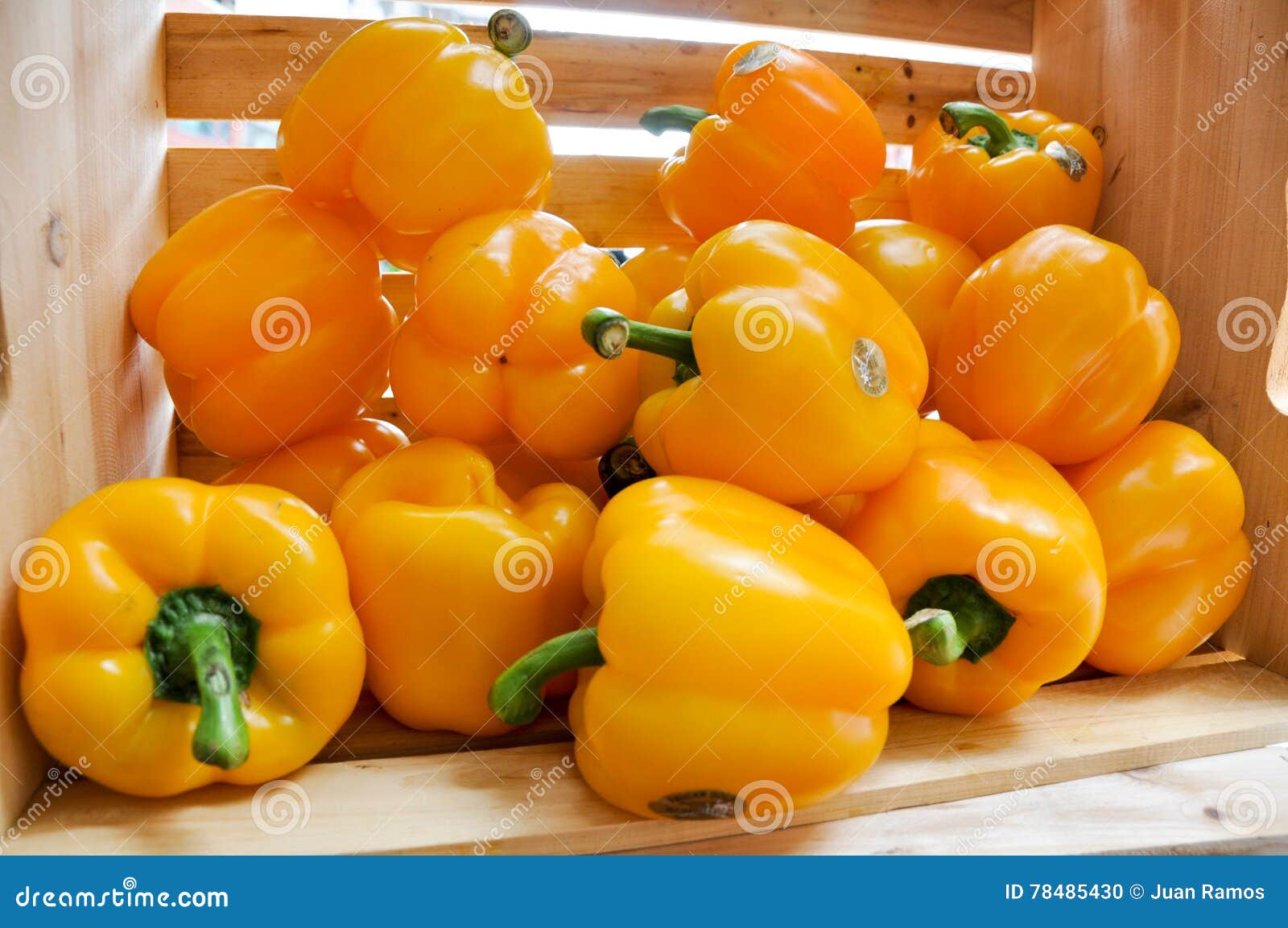 wood crate with yellow bell peppers