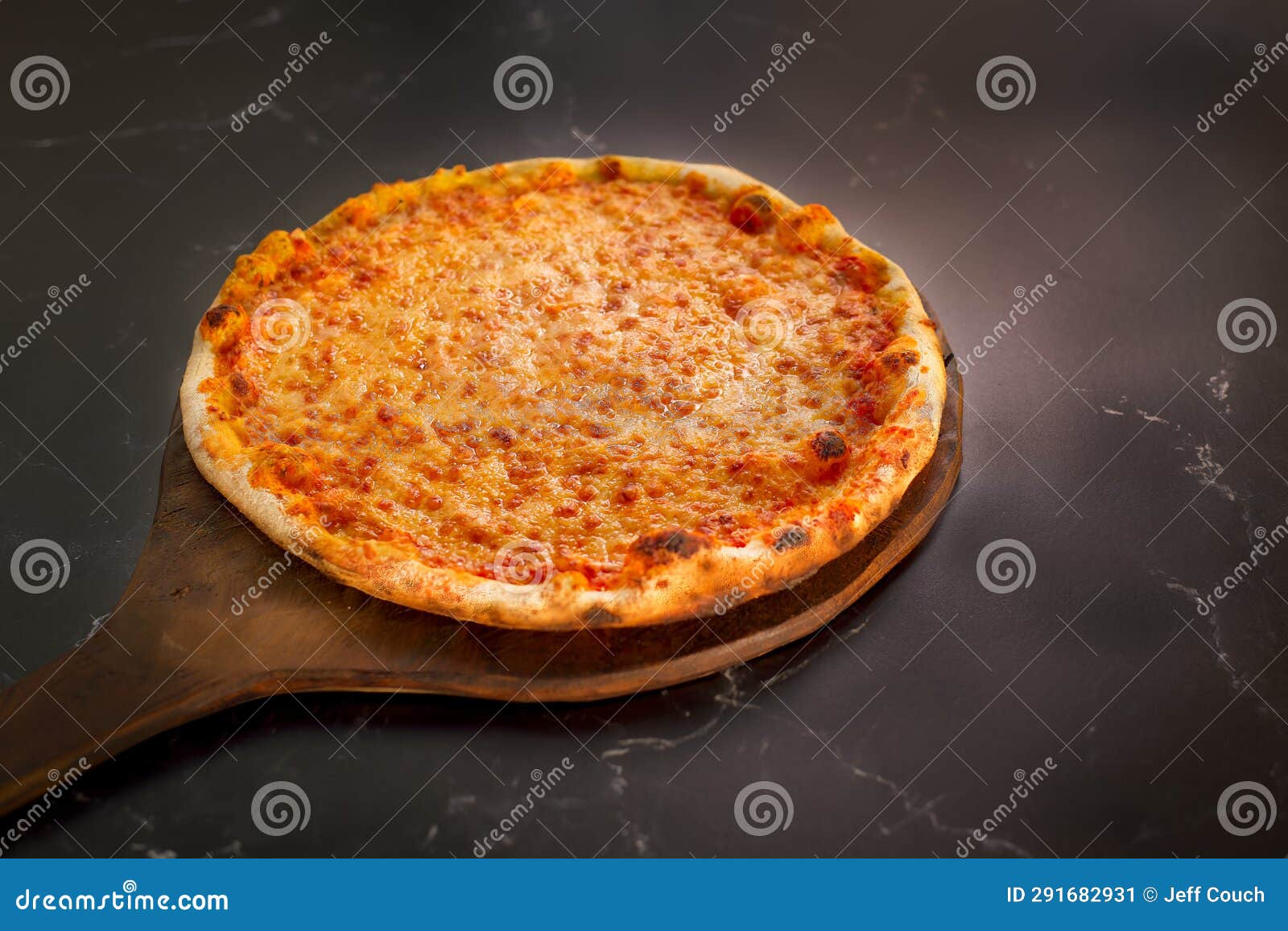 https://thumbs.dreamstime.com/z/wood-fired-cheese-pizza-whole-uncut-peel-sliding-onto-black-marble-counter-top-291682931.jpg