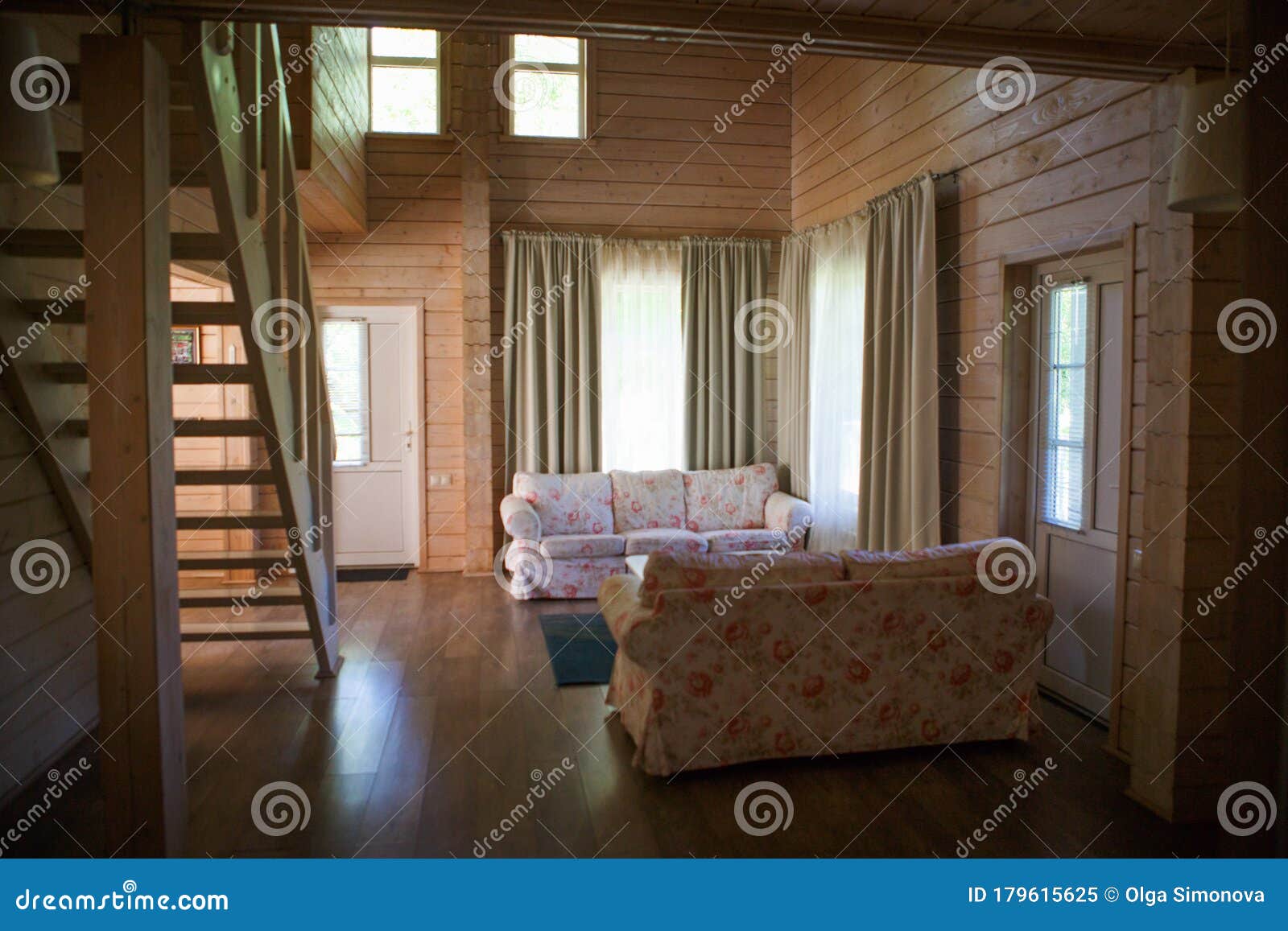 wood interior of the living room in a rustic country house. stairs and a sofa in a bright