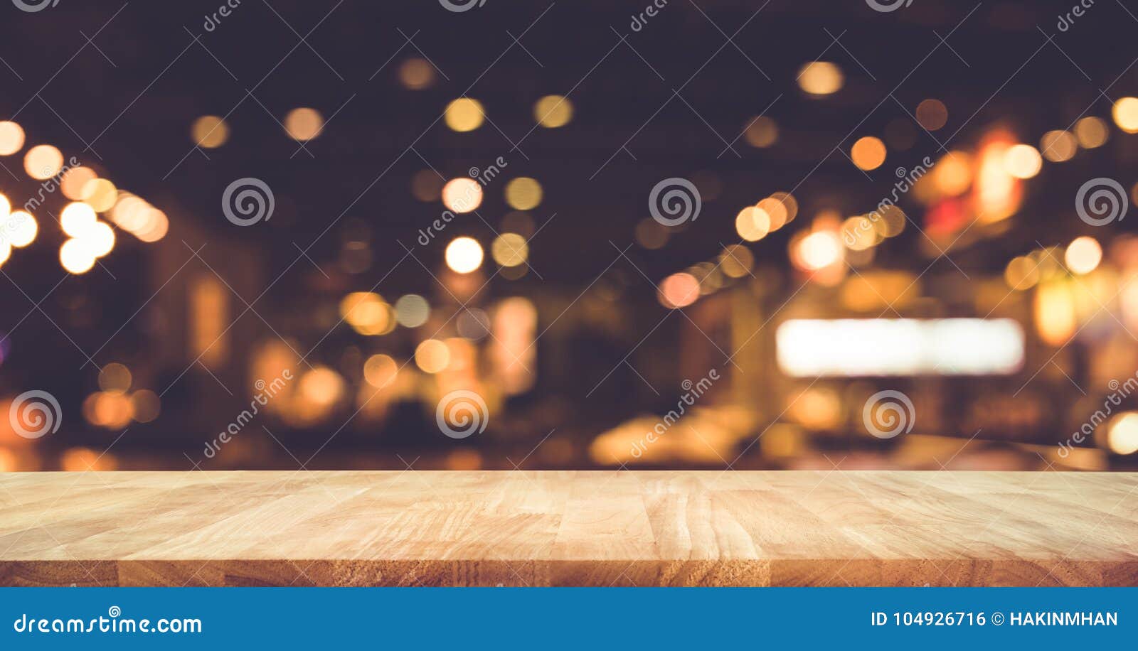 wood table top bar with blur light bokeh in dark night cafe