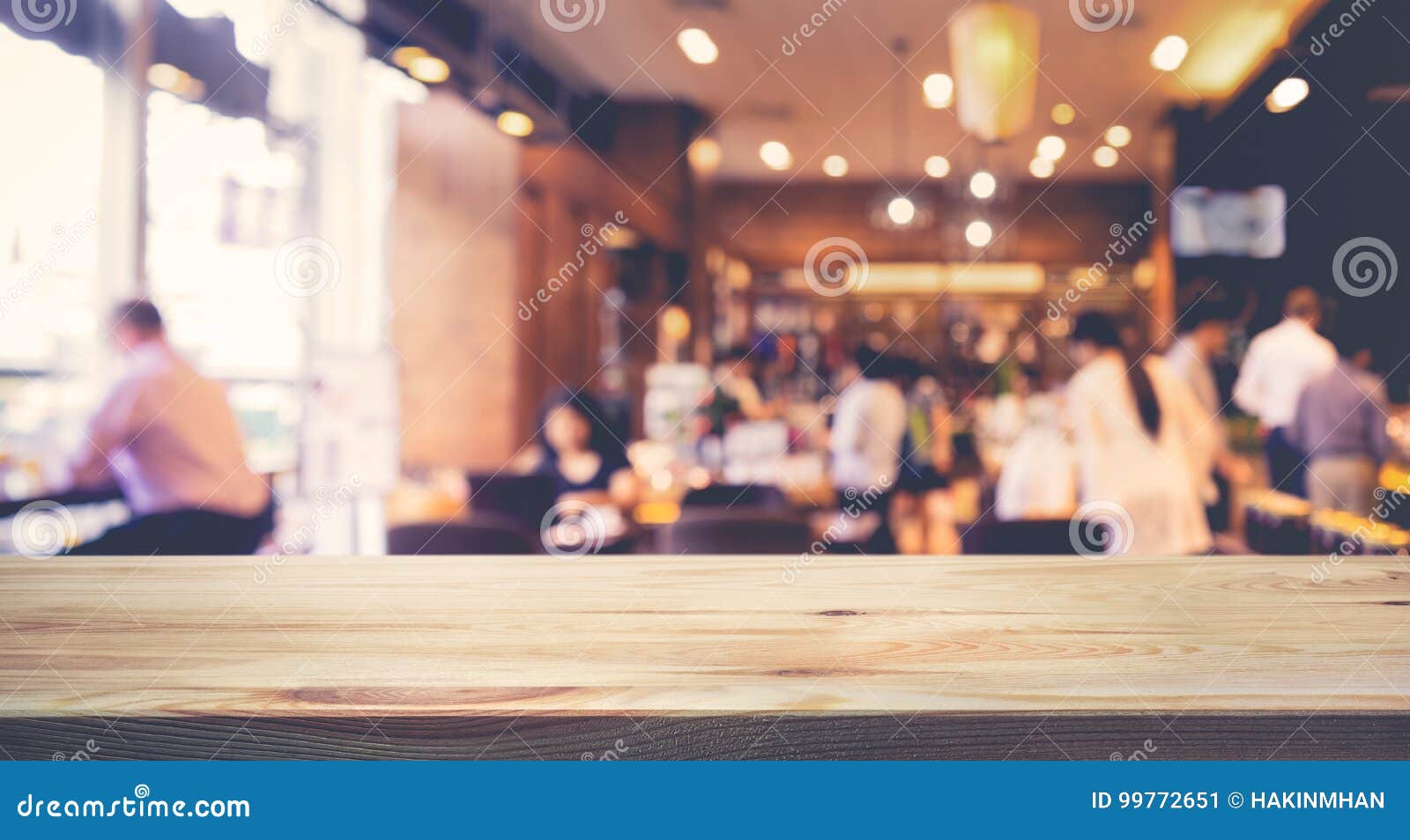 wood table top with blur of people in coffee shop or cafe,restaurant