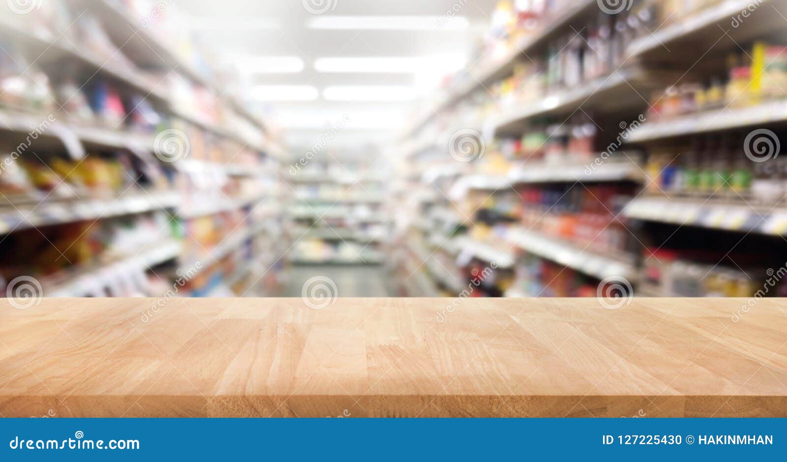 wood table top on blur of supermarket product shelf background.