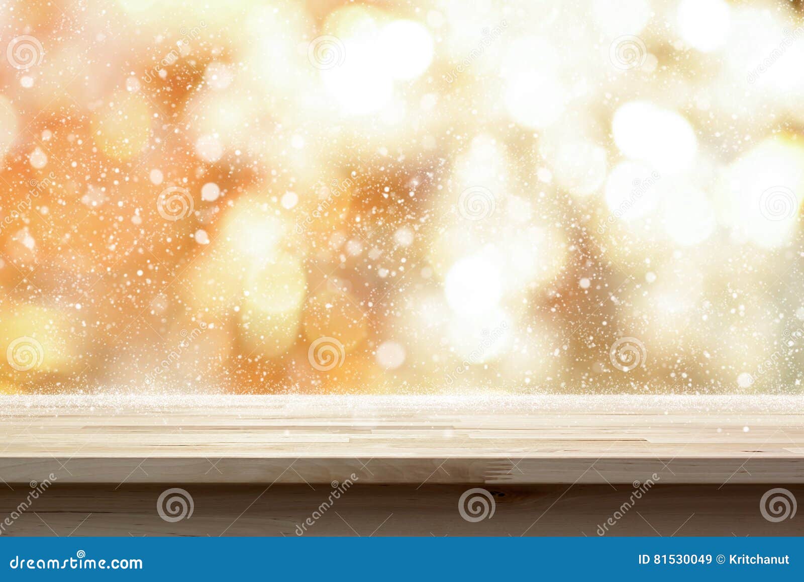 wood table top on shiny gold bokeh abstract background with snow
