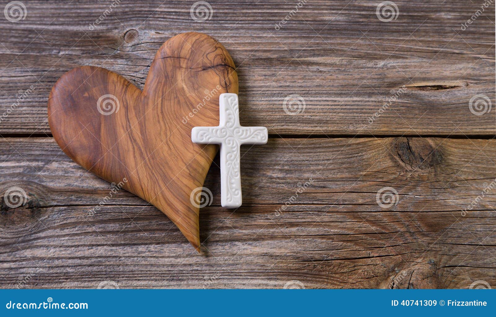 wooden background with olive heart and white cross for an obituary notice.