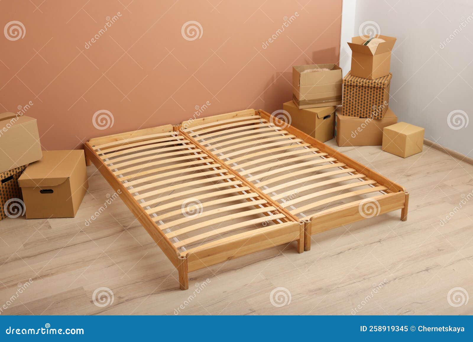 Wooden Bed Frame and Cardboard Boxes on Floor in Room Stock Image