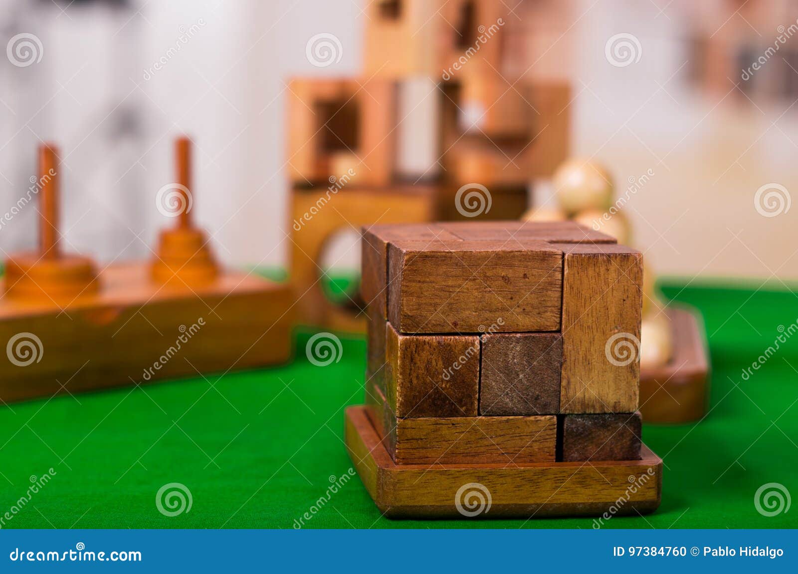 Wooden Block Brain Teaser Puzzle on Green Table in a Blurred Background