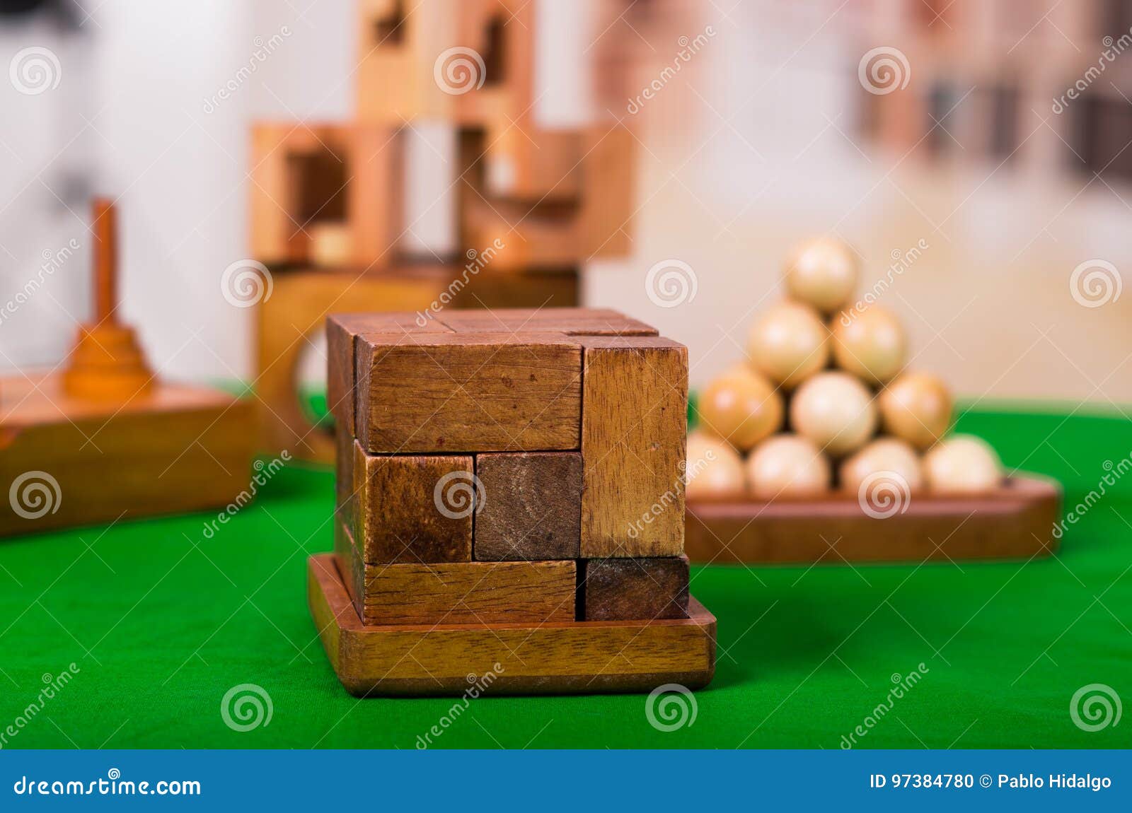 Wooden Block Brain Teaser Puzzle On Green Table In A Blurred Background
