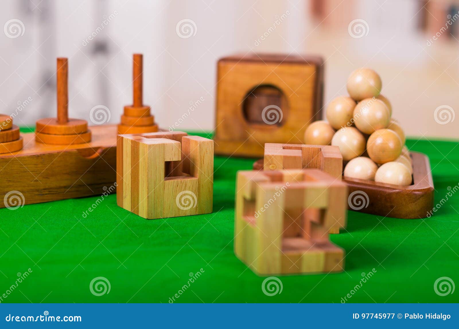 Wooden Block Brain Teaser Puzzle on Green Table in a Blurred Background