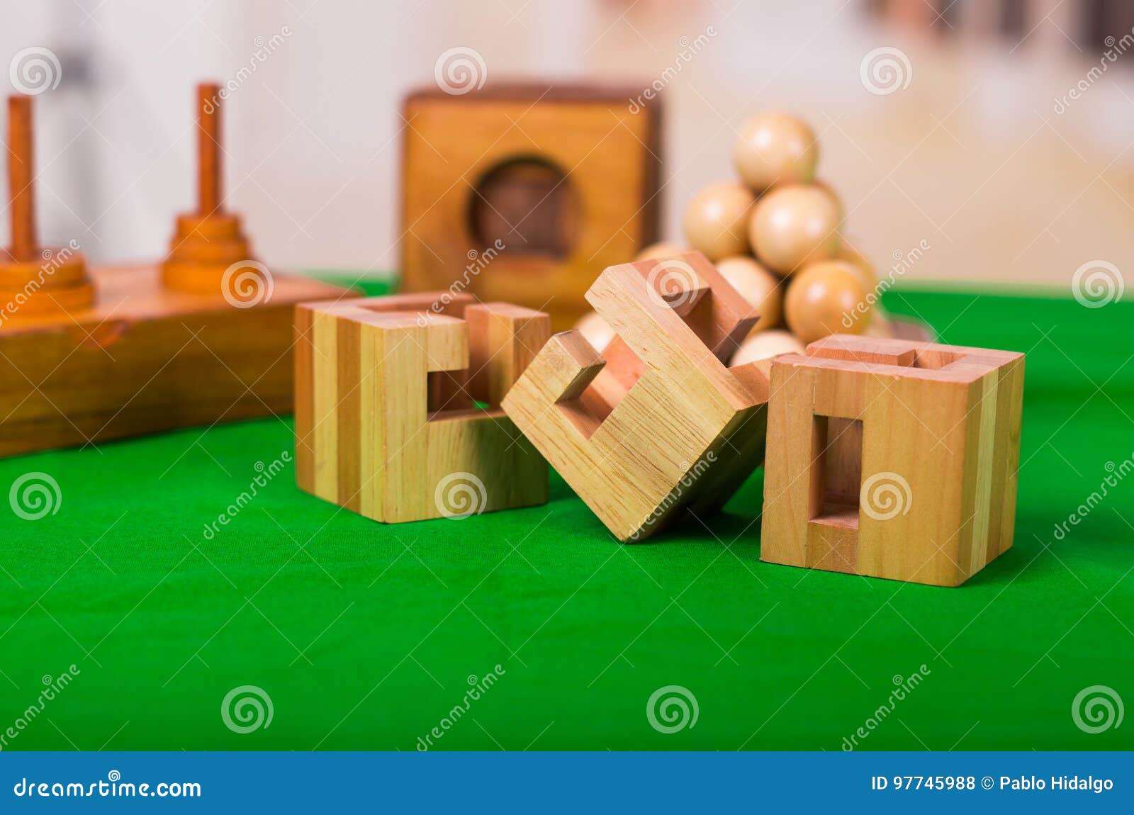 Wooden Block Brain Teaser Puzzle on Green Table in a Blurred Background