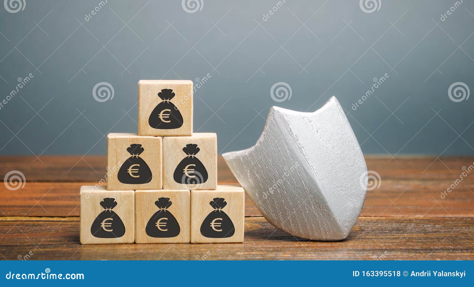 wooden blocks with money and protection shield. concept security of money, guaranteed deposits. client rights protection.
