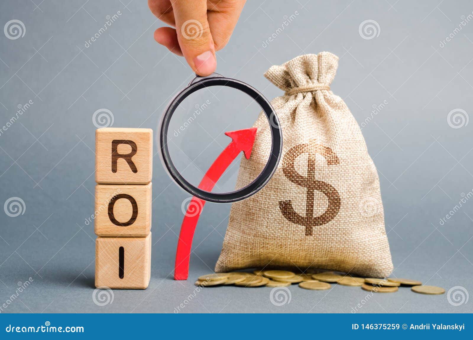 wooden blocks with the word roi and the up arrow with the money bag. high level of business profitability. return on investment,