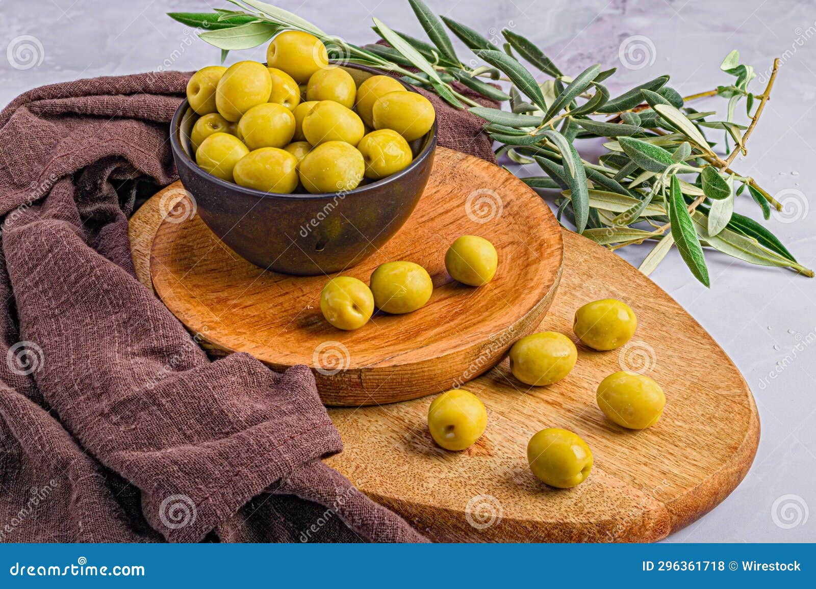 wooden board with an array of ripe green manzanilla olives and other decorations