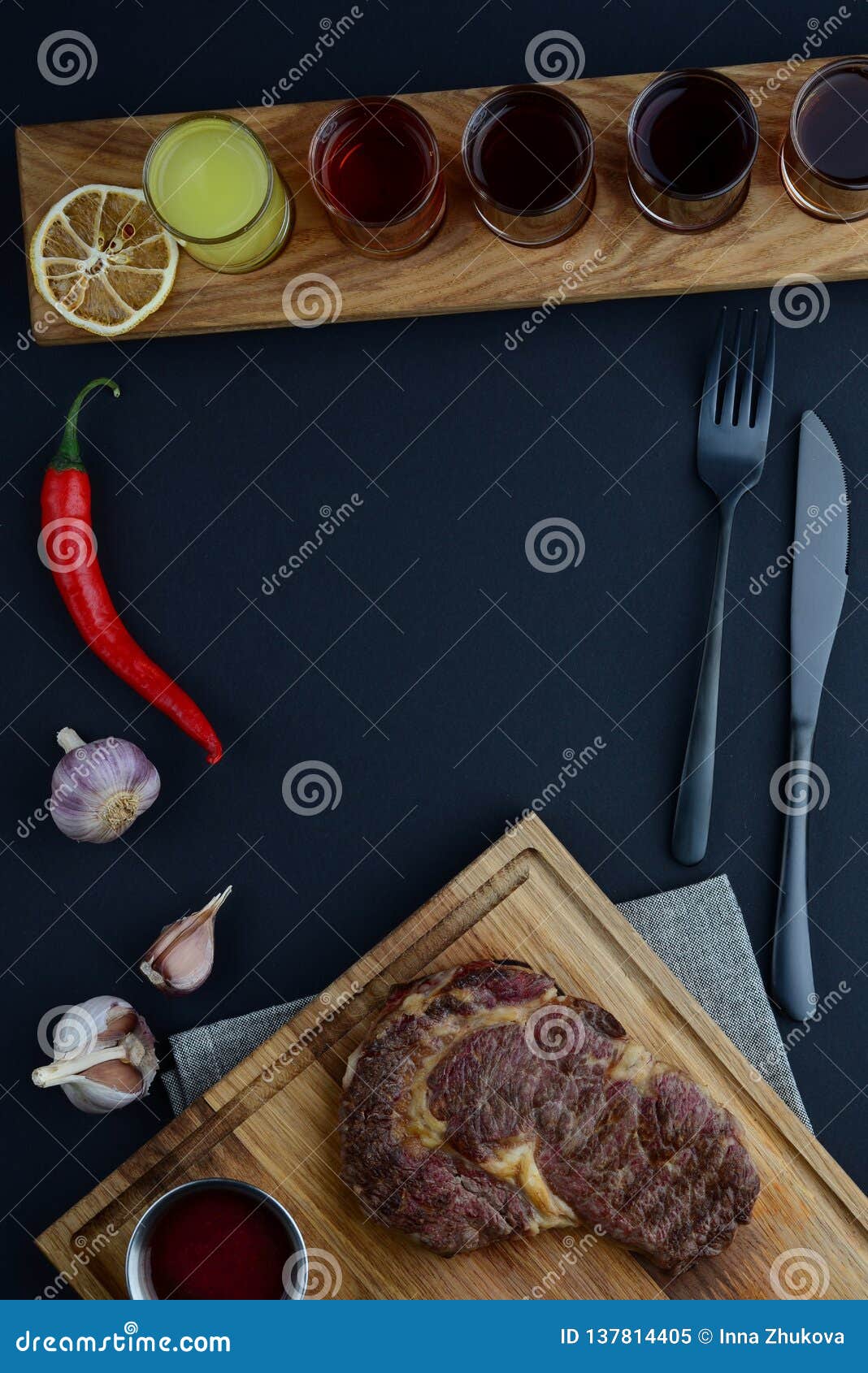 wooden board with shots near red pepper, cutlery and garlic