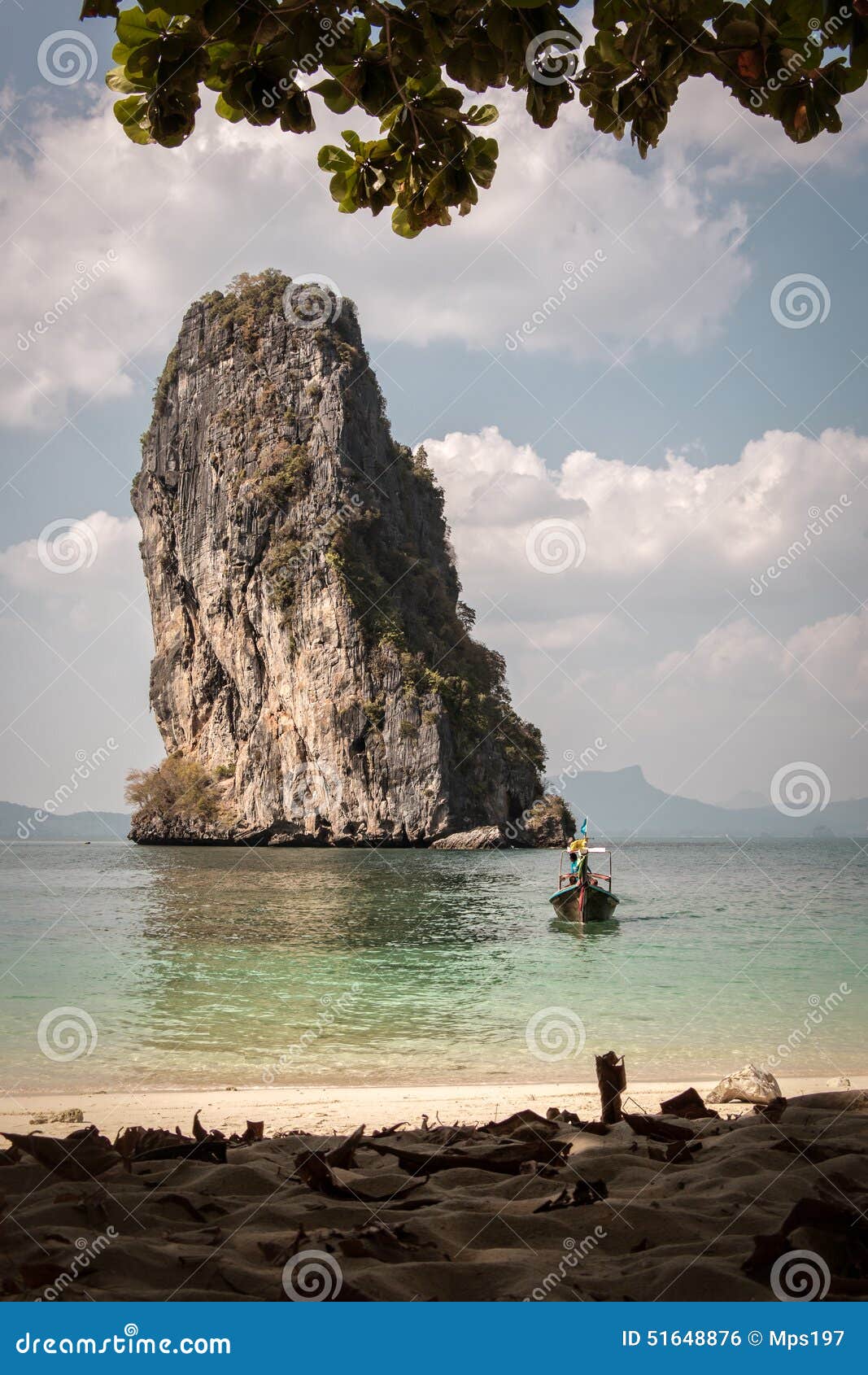 wooden boat arriving on beach with rocky cliff