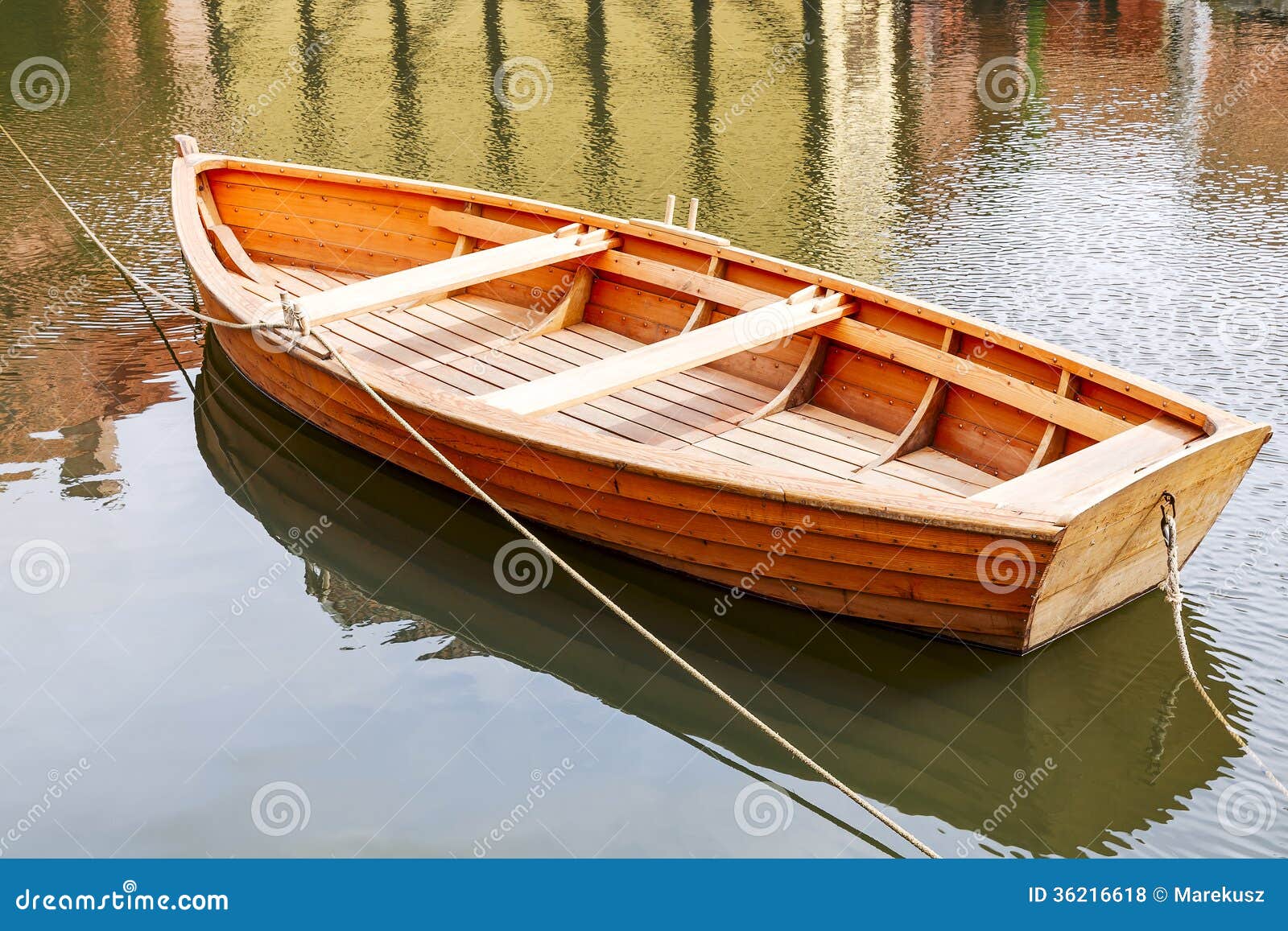 Small fishing boat on the water moored at a distance from the shore.