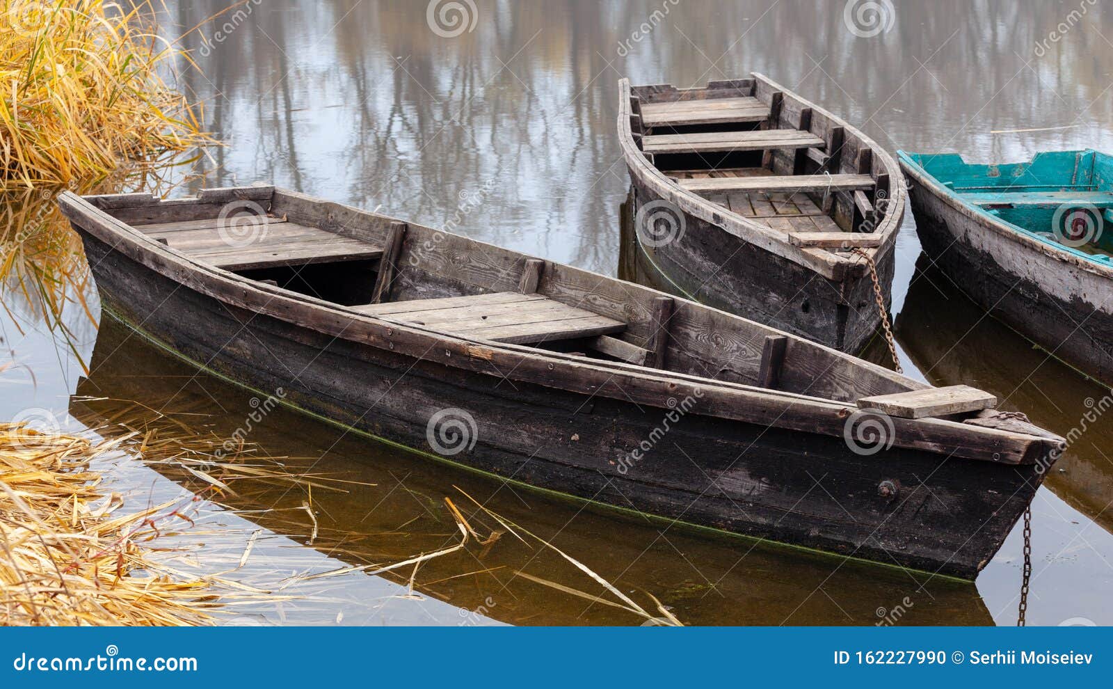 https://thumbs.dreamstime.com/z/wooden-boats-river-autumn-closeup-old-wooden-fishing-boats-river-fall-reflections-trees-water-162227990.jpg