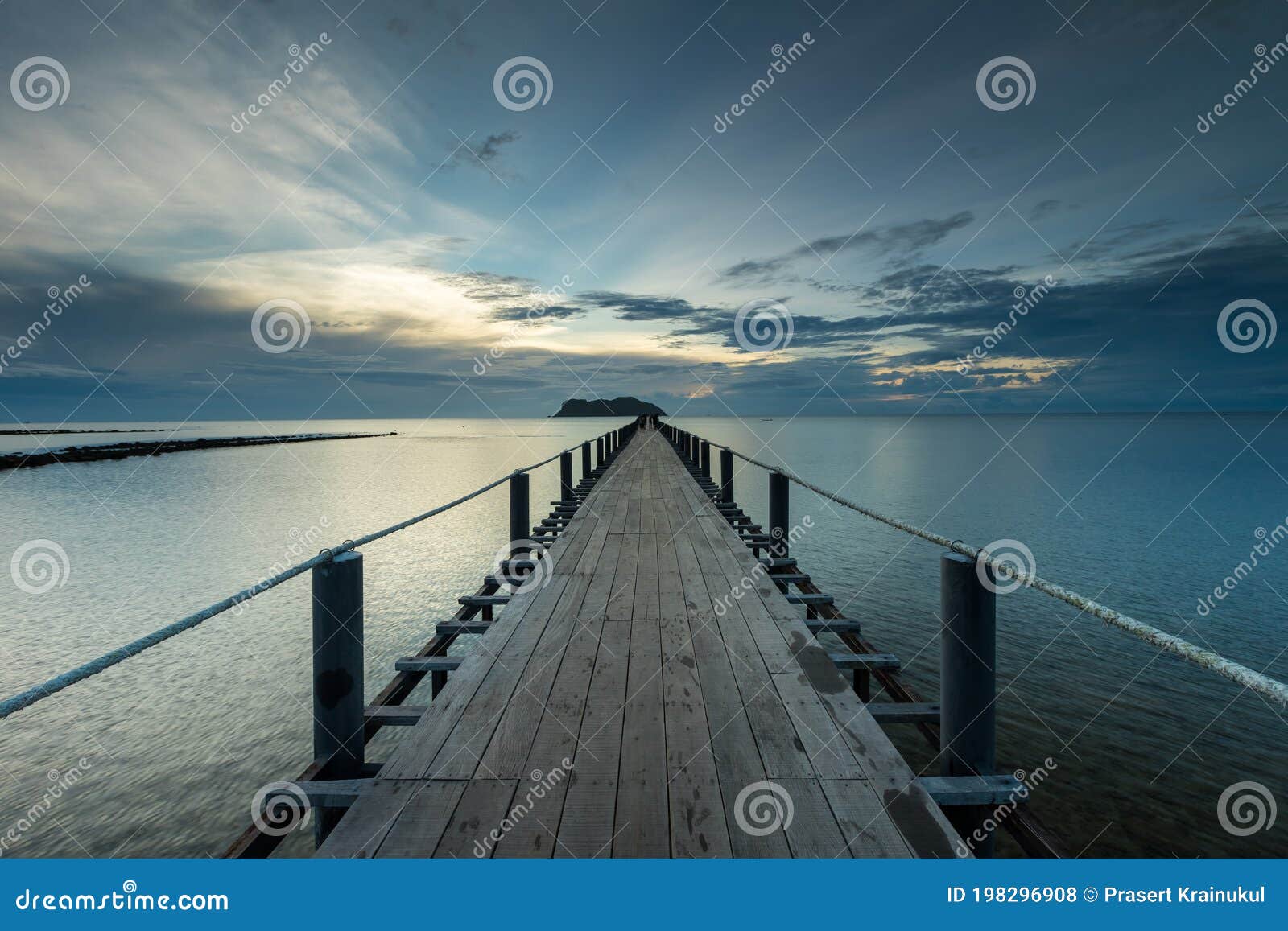 wooden bridge stretching down to the sea to be used for boarding the boat at thung makham noi pier, chumphon, thailand