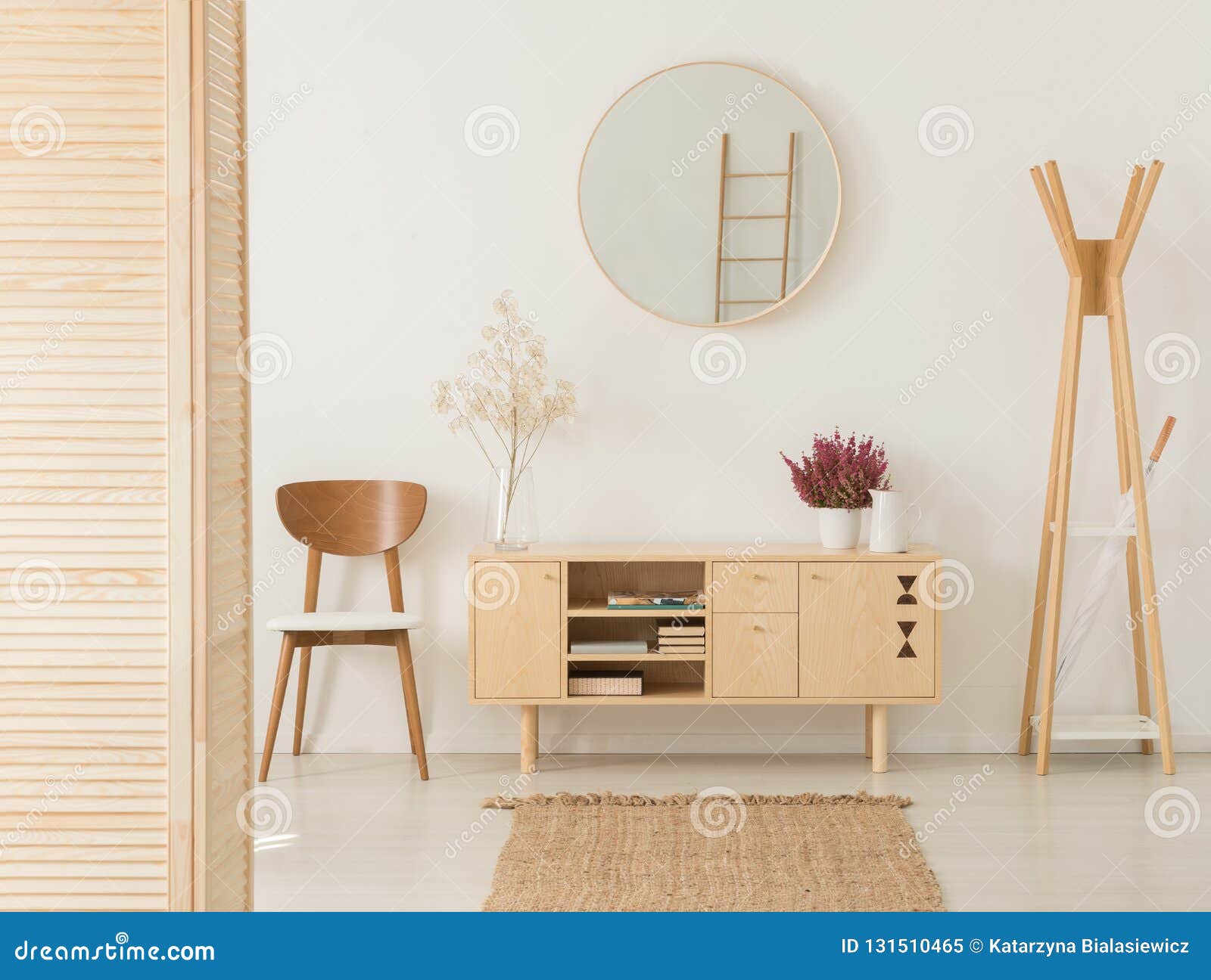 wooden cabinet with flowers between stylish brown chair and wooden hanger