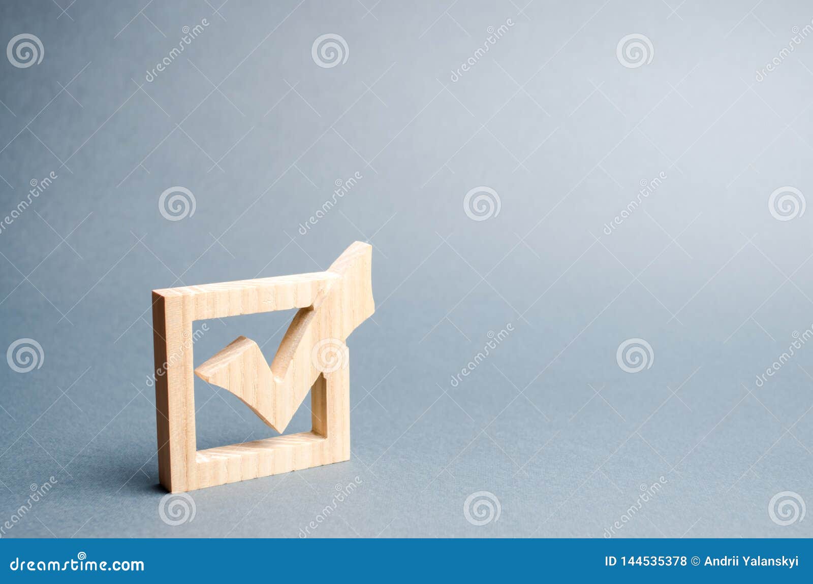 wooden checkmark for voting on elections on a gray background. presidency or parliamentary elections, a referendum. survey of the