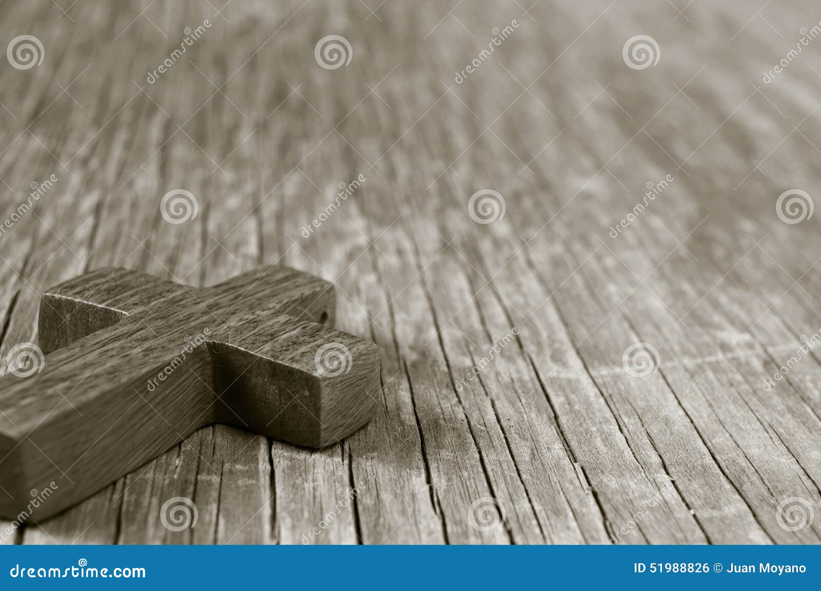 wooden christian cross on a rustic wooden surface, sepia toning