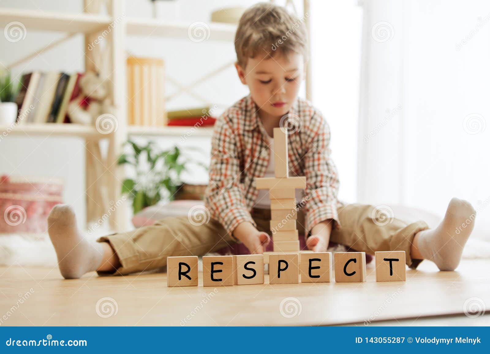 wooden cubes with word respect in hands of little boy